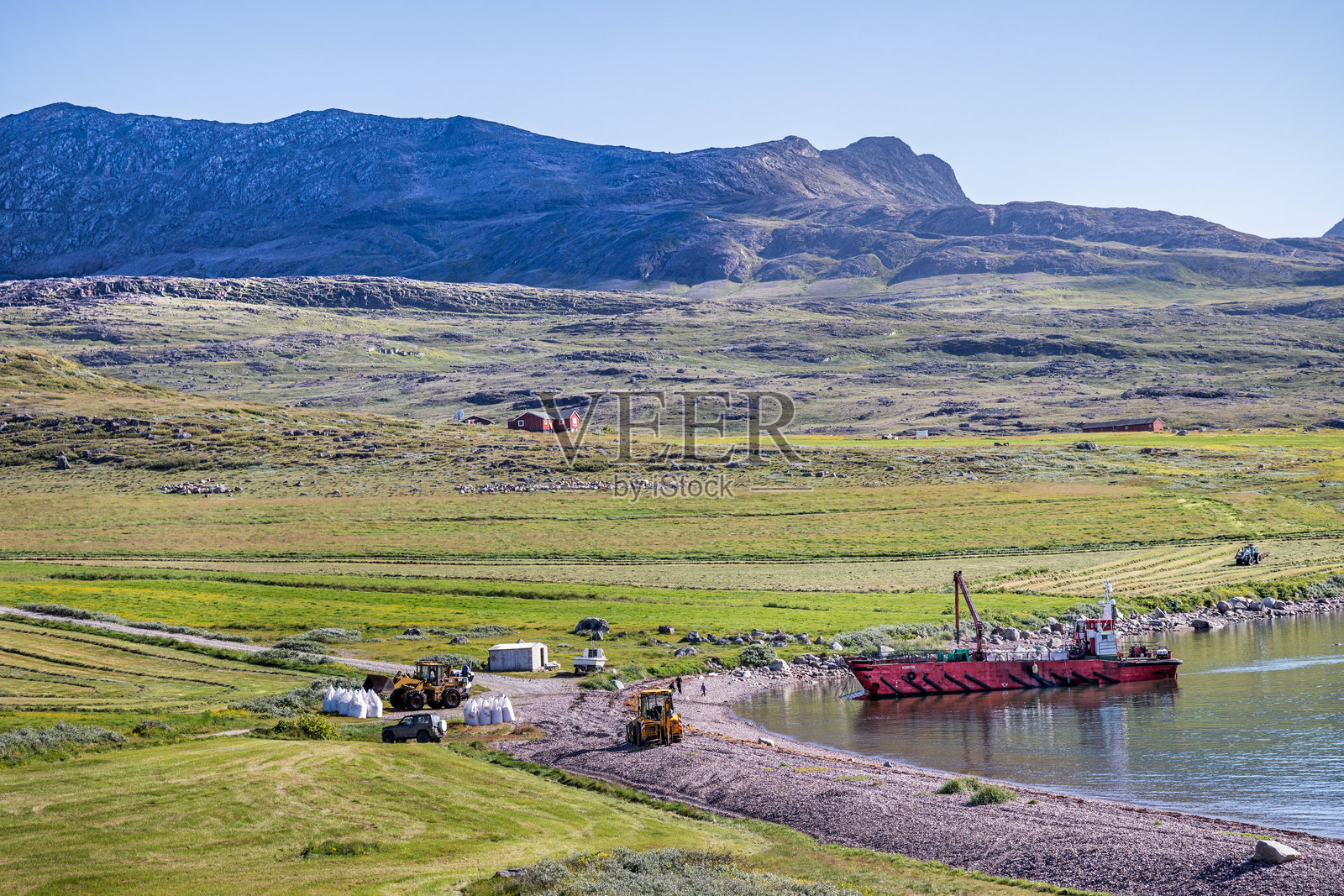 船只将货物运送到北极峡湾的石滩上照片摄影图片