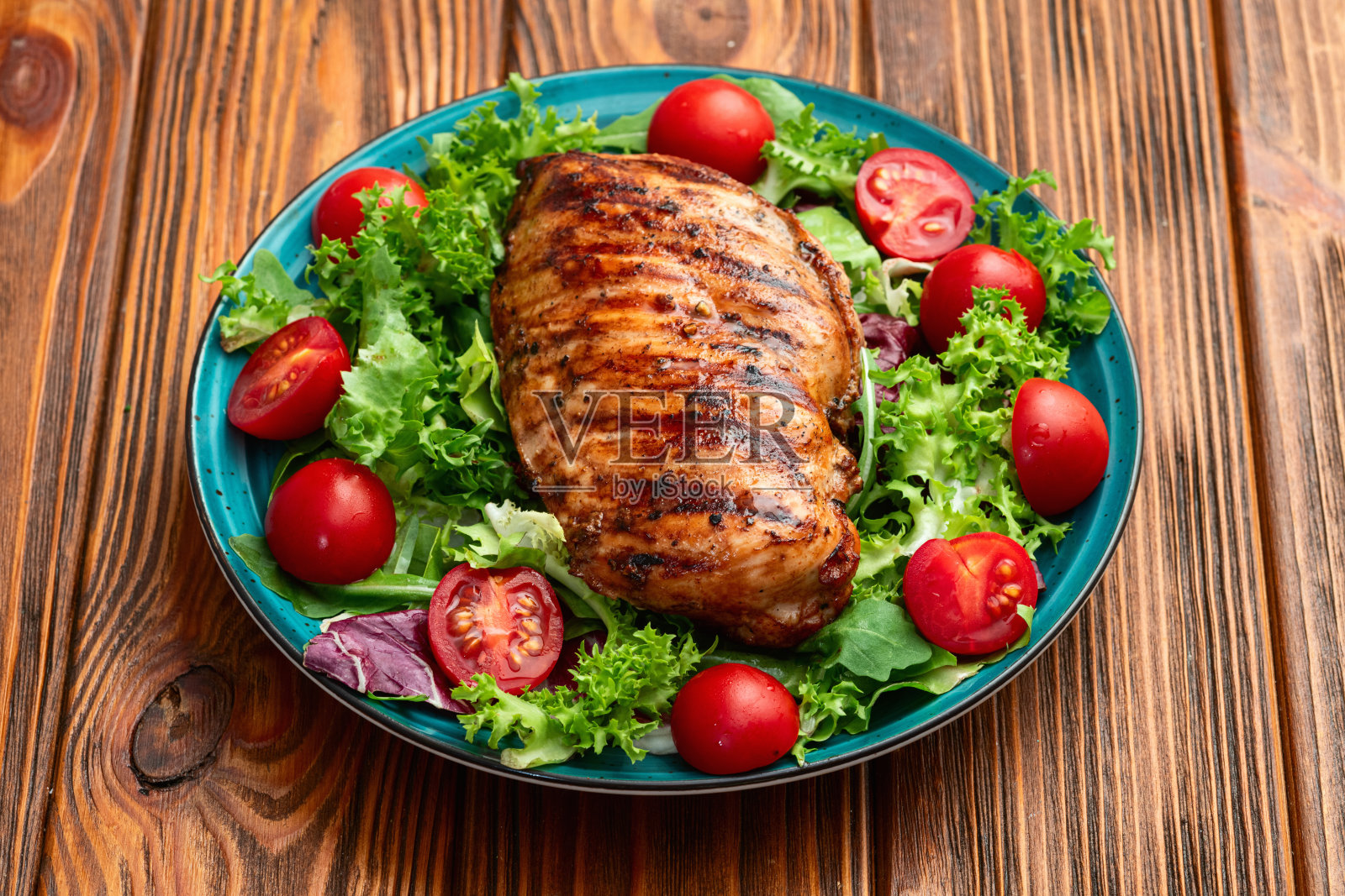 烤鸡胸肉（肉片）配生菜沙拉和樱桃番茄。俯视图照片摄影图片