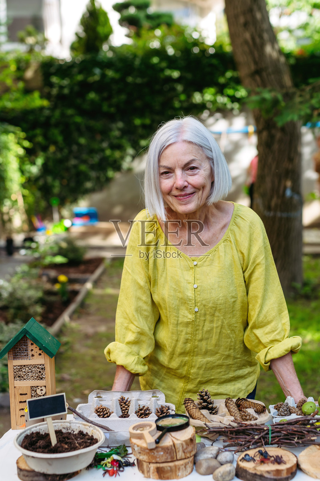户外可持续教育中的教师，在森林学校进行课程。将蔬菜幼苗种植在土壤中。体验式学习和生态素养的概念。照片摄影图片