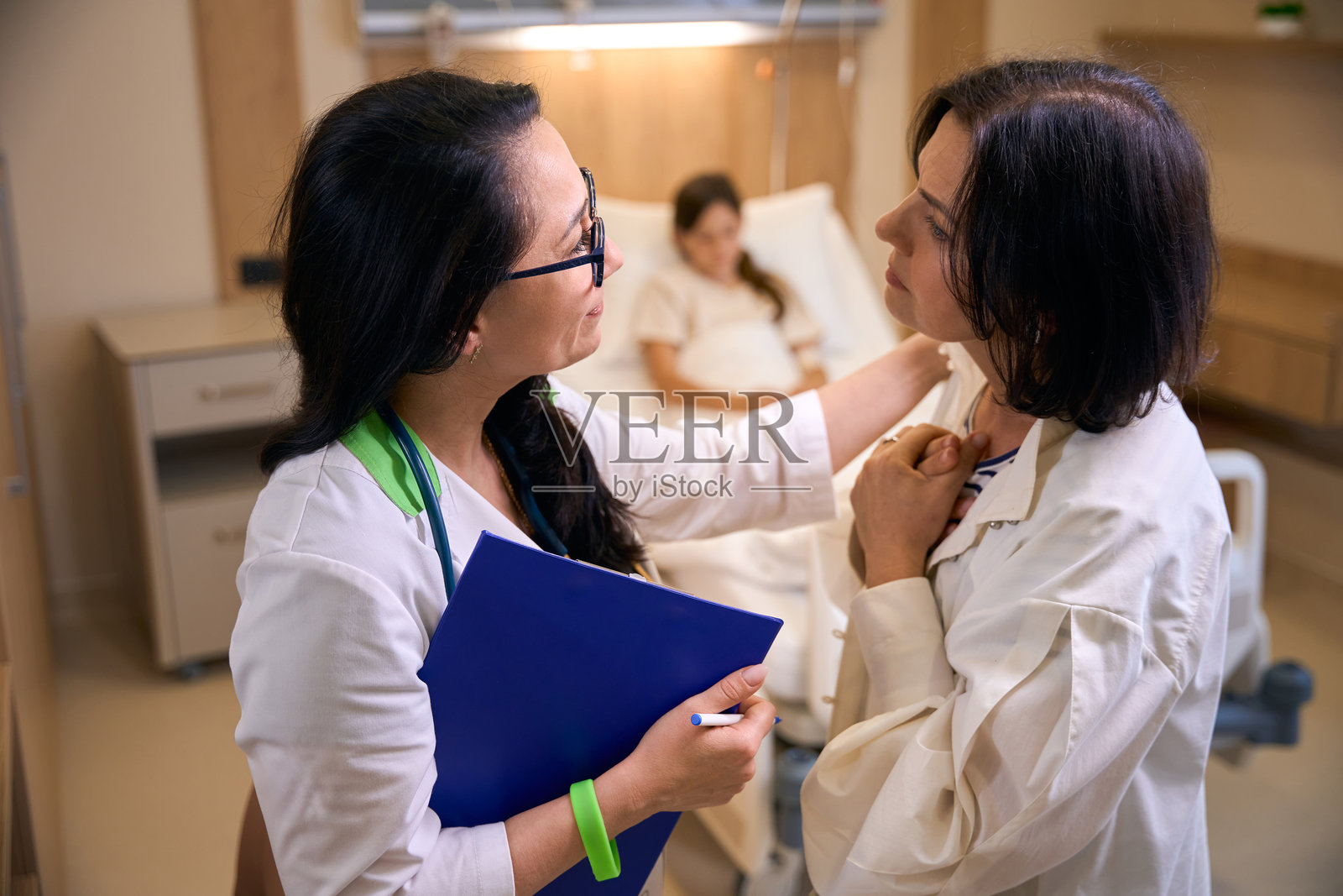 女儿科医生安慰生病女孩的母亲照片摄影图片