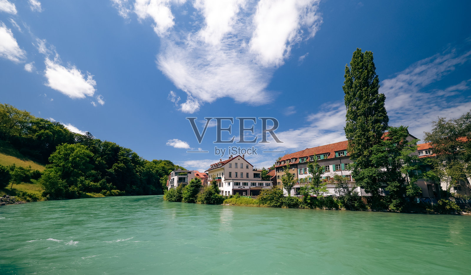 瑞士伯尔尼阿尔河畔宁静的下午，绿意盎然，迷人的建筑环绕。照片摄影图片