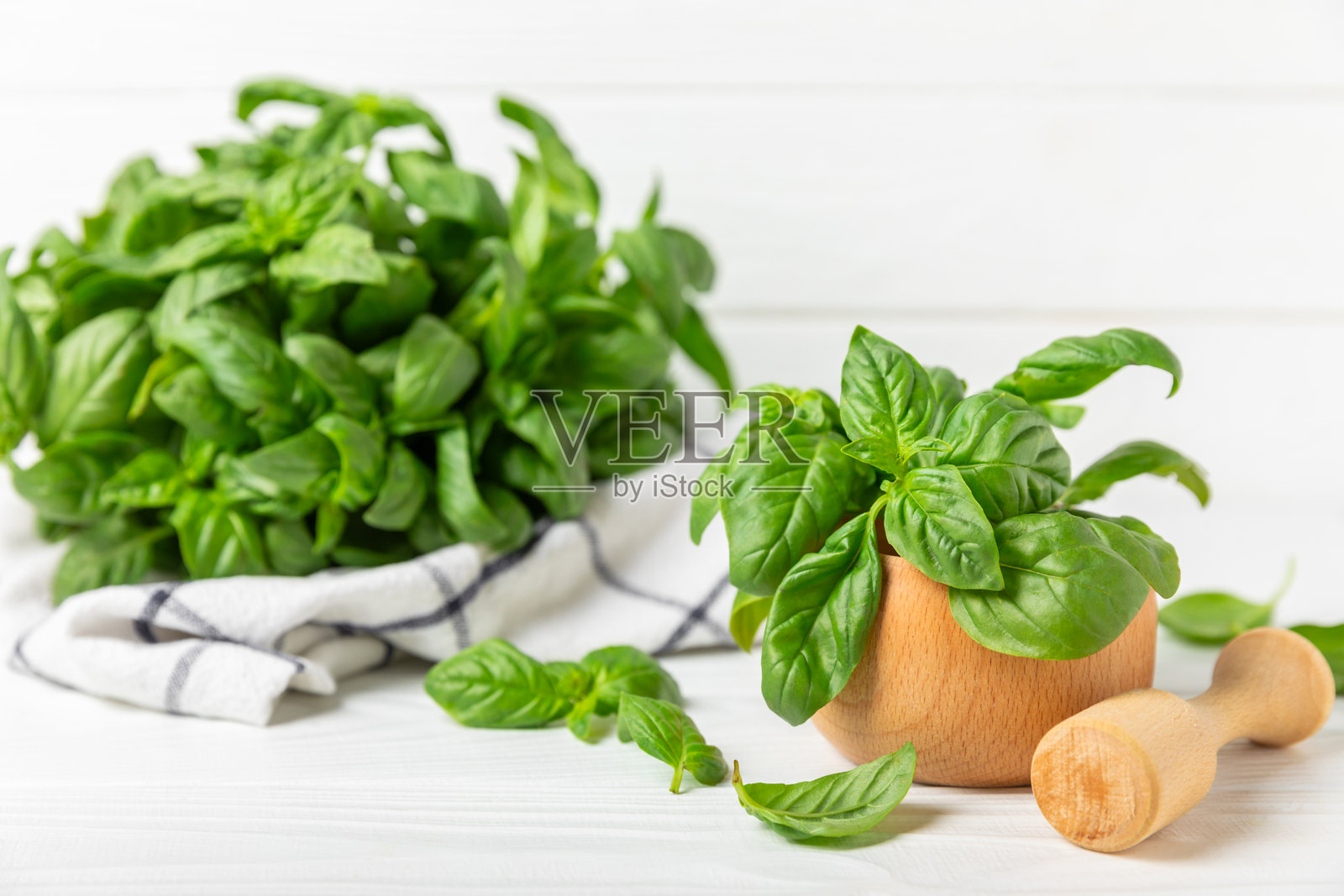 新鲜的绿色罗勒放在有纹理的木质背景上的研钵中。 有机香料和草药。 纯素。 新鲜的厨房草药。 新鲜罗勒与研杵一起制作香蒜酱。 留白。 文本位置。照片摄影图片