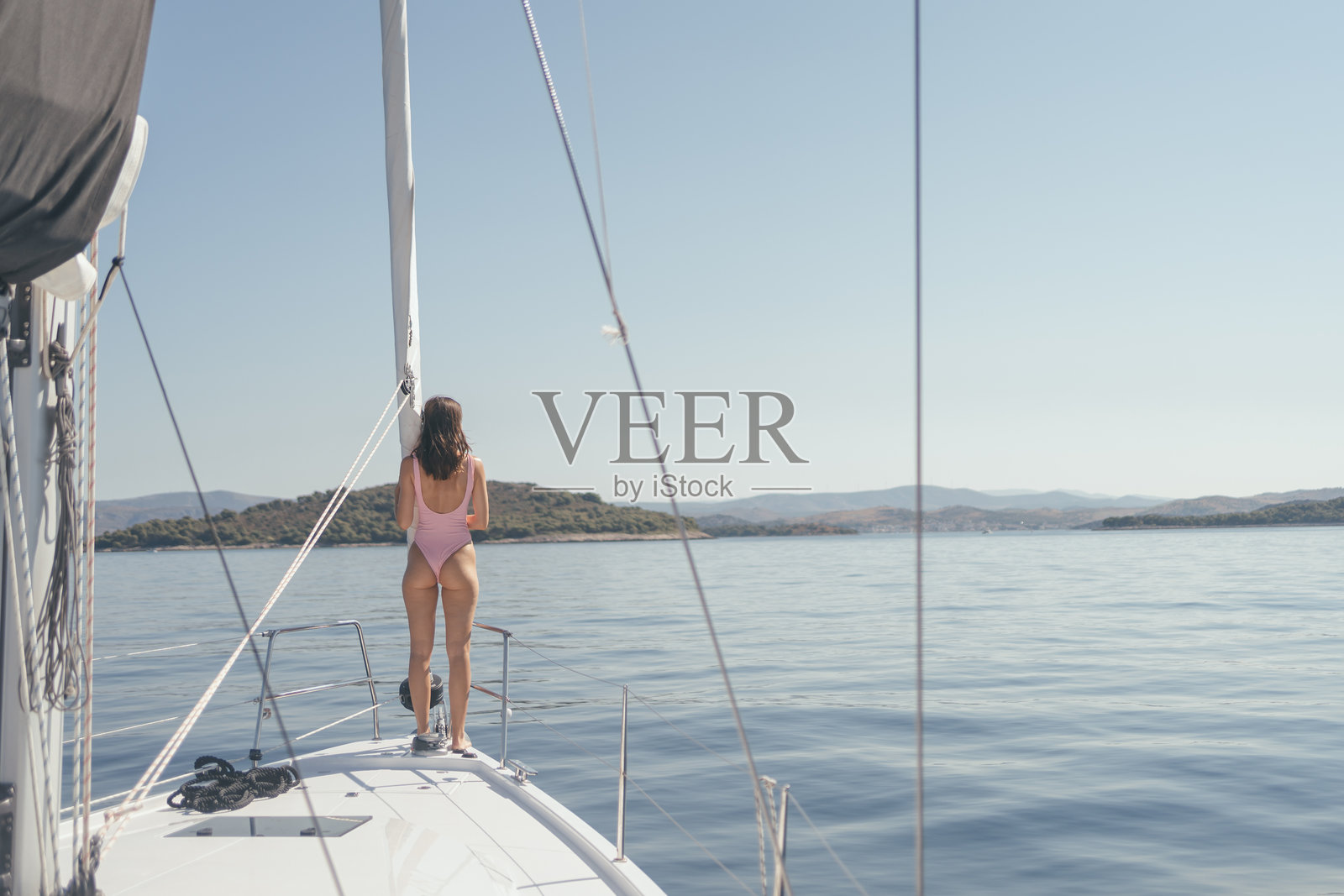 年轻女性在阳光下的帆船上放松。照片摄影图片