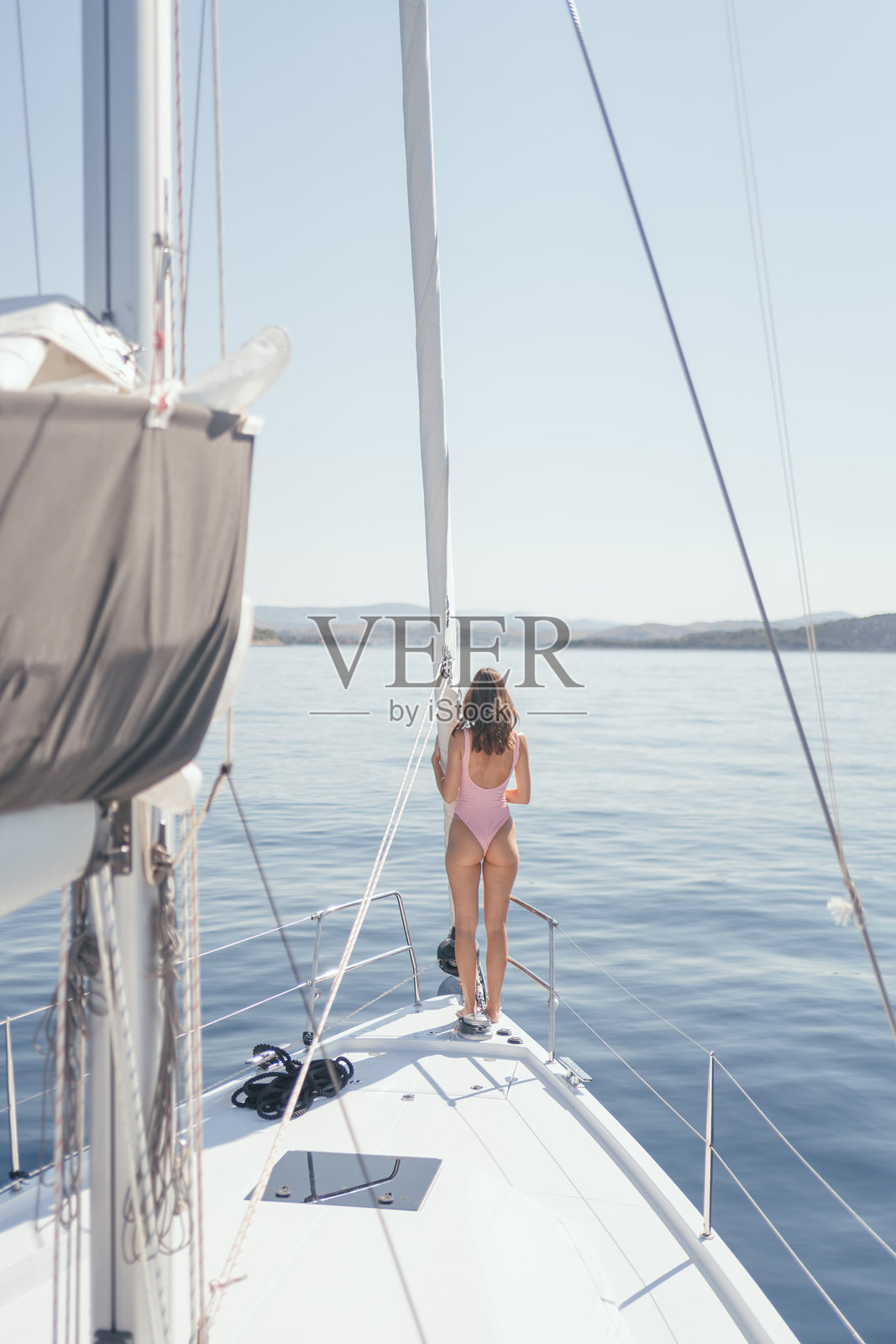 年轻女性在阳光下的帆船上放松。照片摄影图片