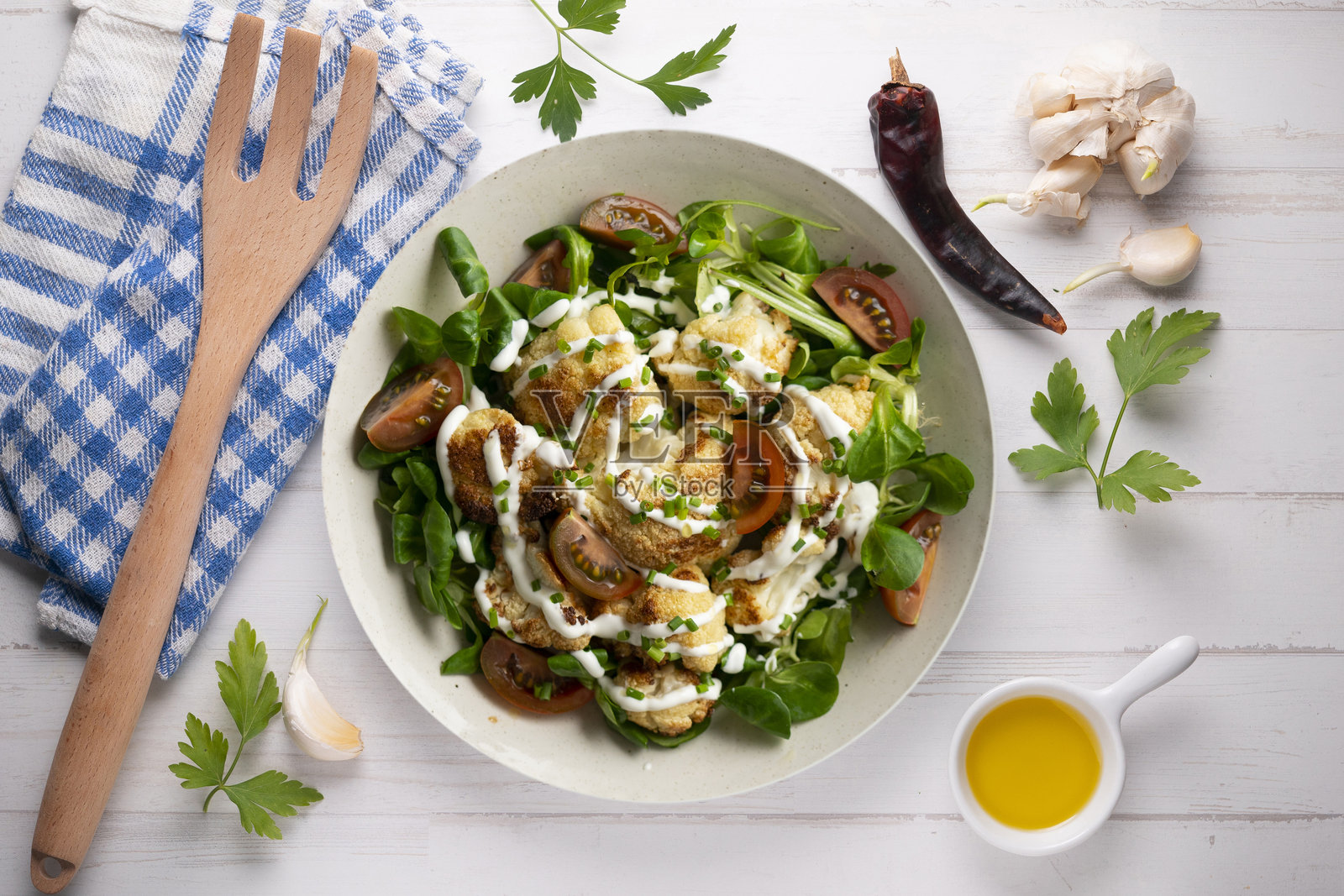 烤花椰菜沙拉配蔬菜和酸奶酱。俯视桌面。照片摄影图片