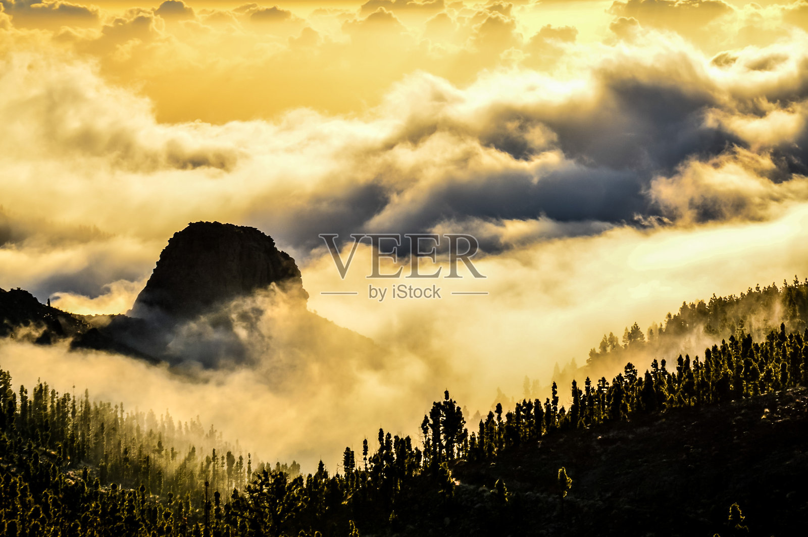 被雾气笼罩的山脉，前景有一块大石头照片摄影图片