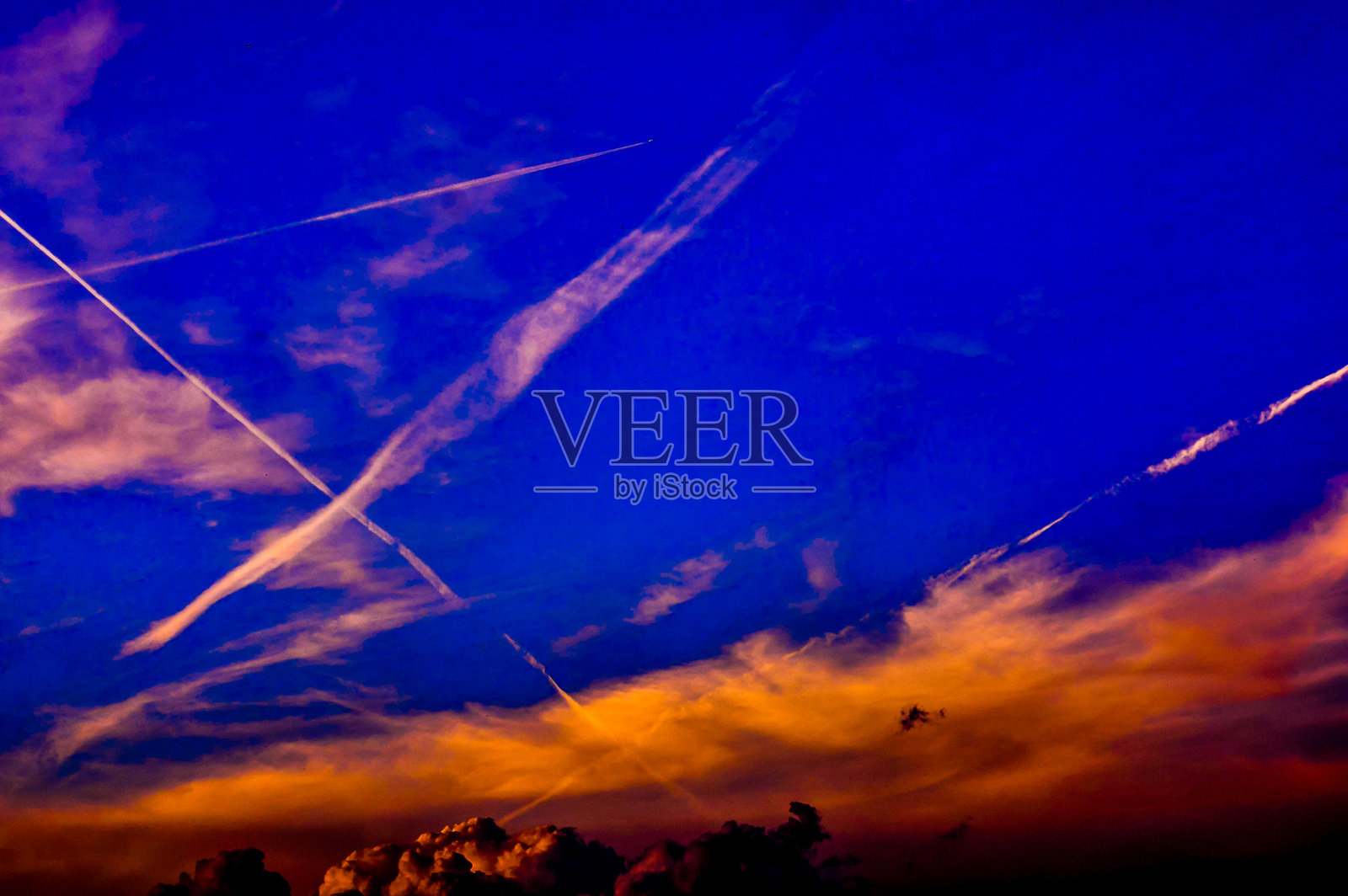 天空湛蓝，飘着几朵白云和几道白色的云彩。照片摄影图片