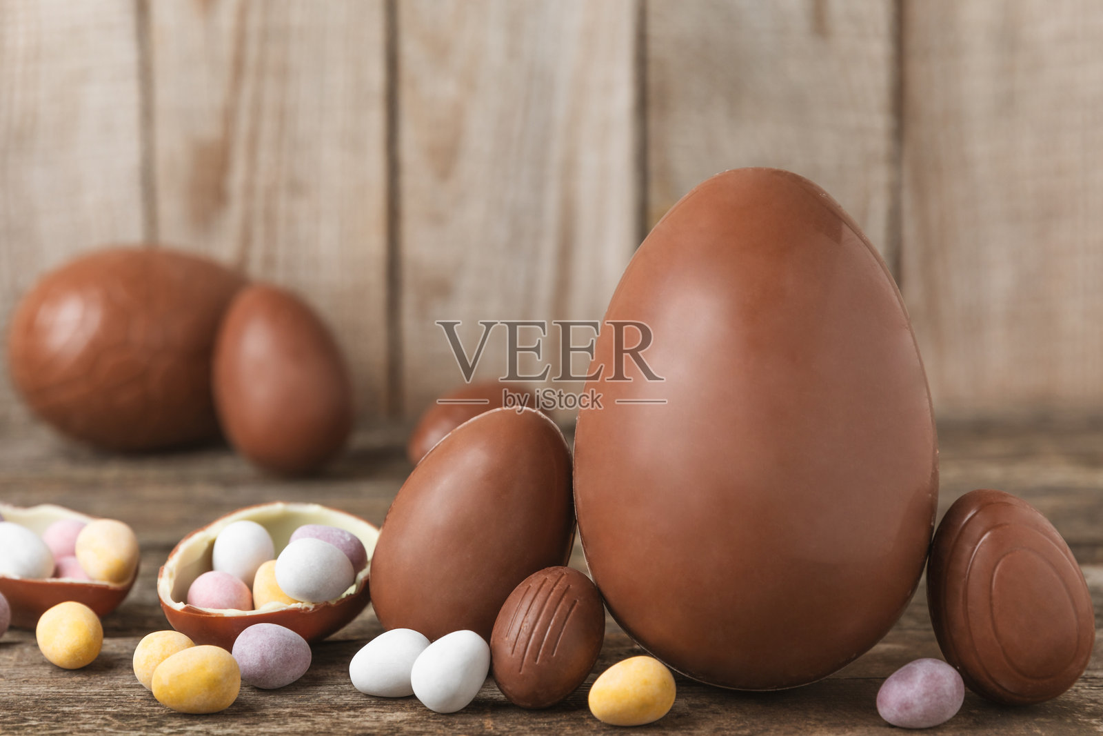复活节巧克力蛋在纹理背景上。复活节庆祝概念。复活节巧克力兔。巧克力甜蛋。纹理木桌上的糖果。留白空间。礼物。横幅。照片摄影图片