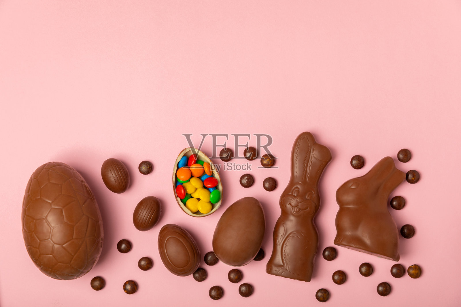 复活节巧克力蛋在纹理背景上。复活节庆祝概念。复活节巧克力兔。巧克力甜蛋。纹理木桌上的糖果。留白。礼物。横幅。照片摄影图片