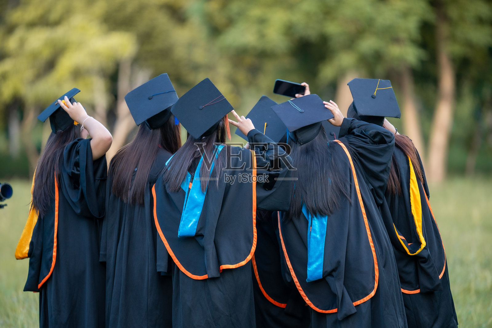 一群穿着毕业袍的女性站在田野里照片摄影图片