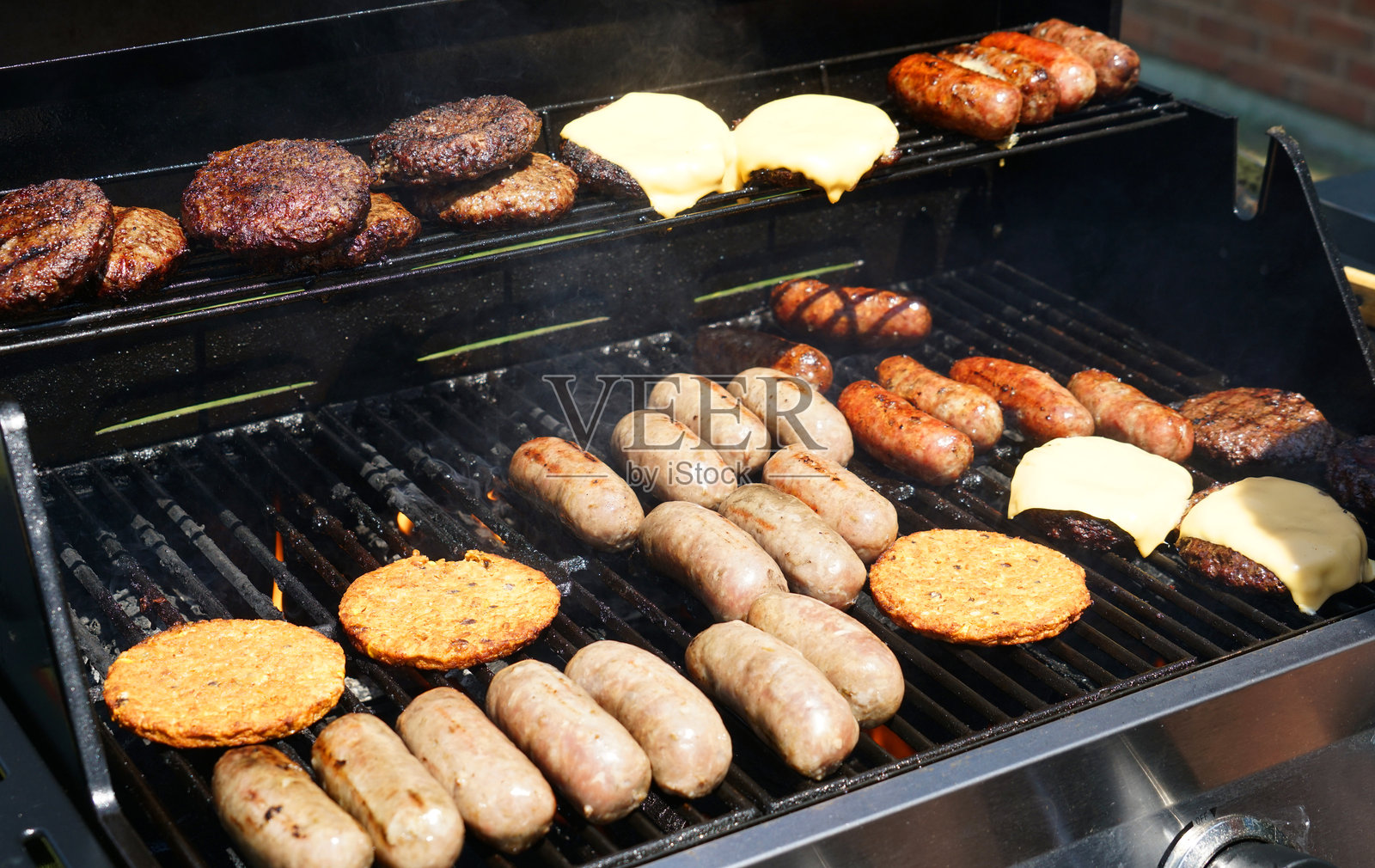 在聚会上用烧烤架烹饪肉类和蔬菜照片摄影图片