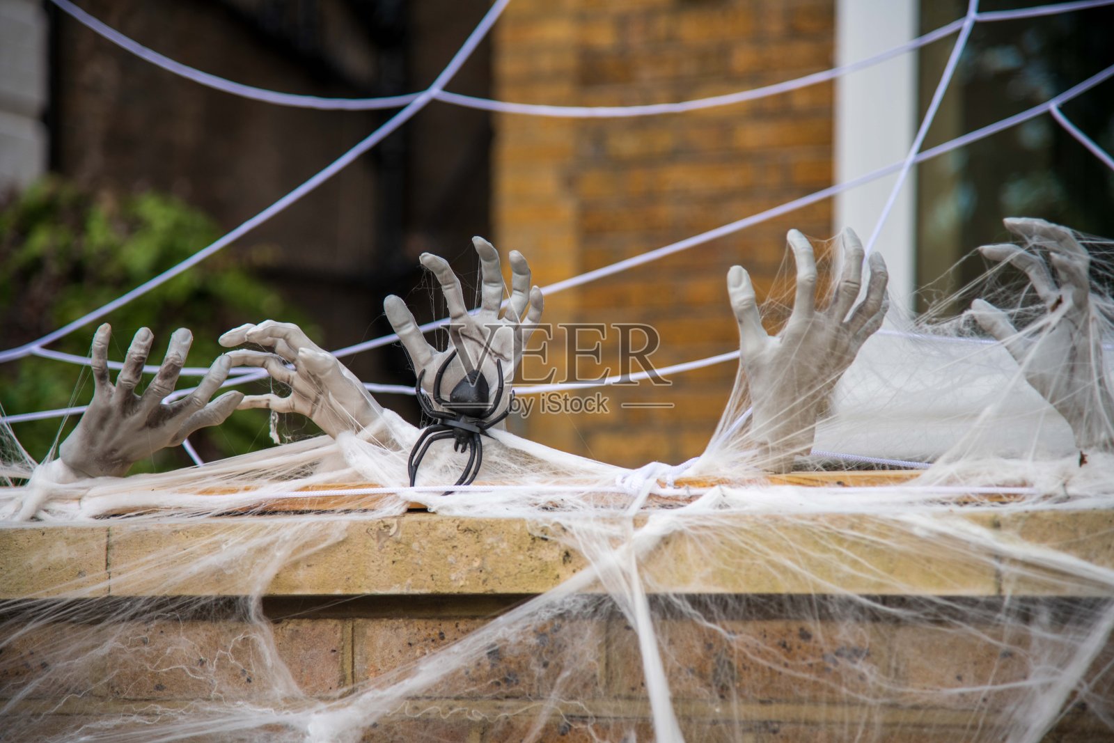 万圣节的蜘蛛网覆盖墙壁上伸出的手照片摄影图片