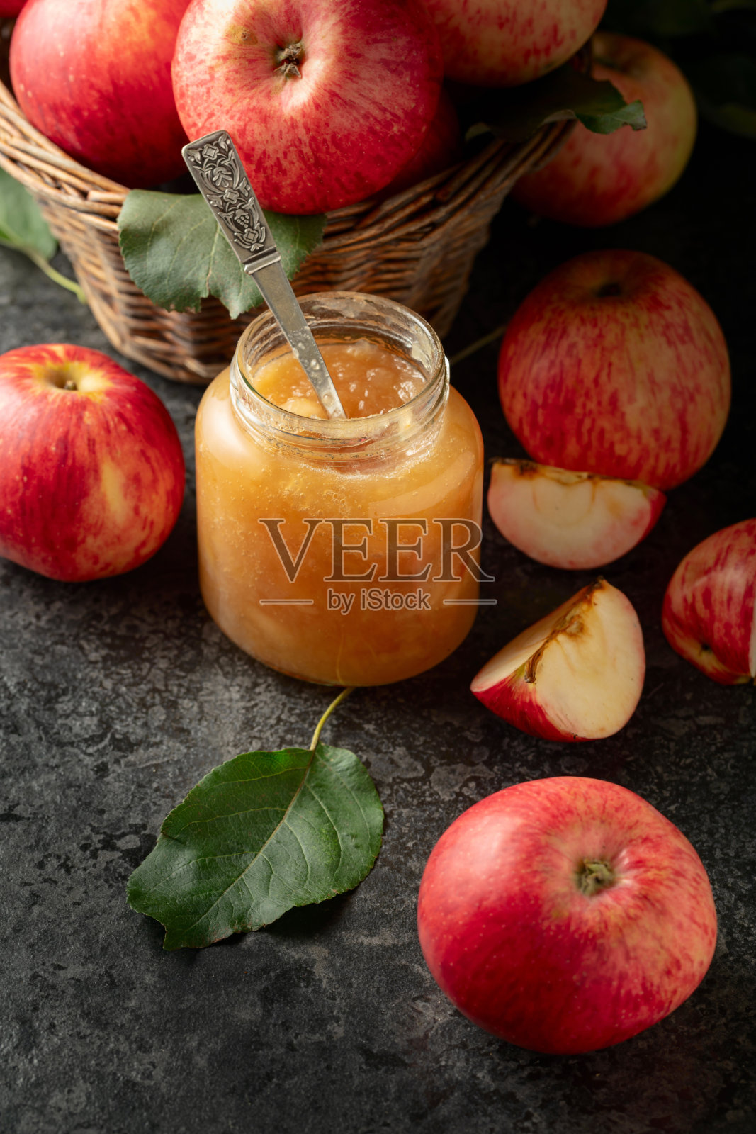 黑色石桌上的苹果果酱和新鲜苹果。照片摄影图片