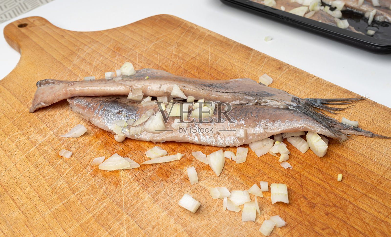 荷兰鲱鱼在木砧板上，盐腌鱼肉片，传统的马特耶斯，新鲜的大西洋鲱鱼照片摄影图片