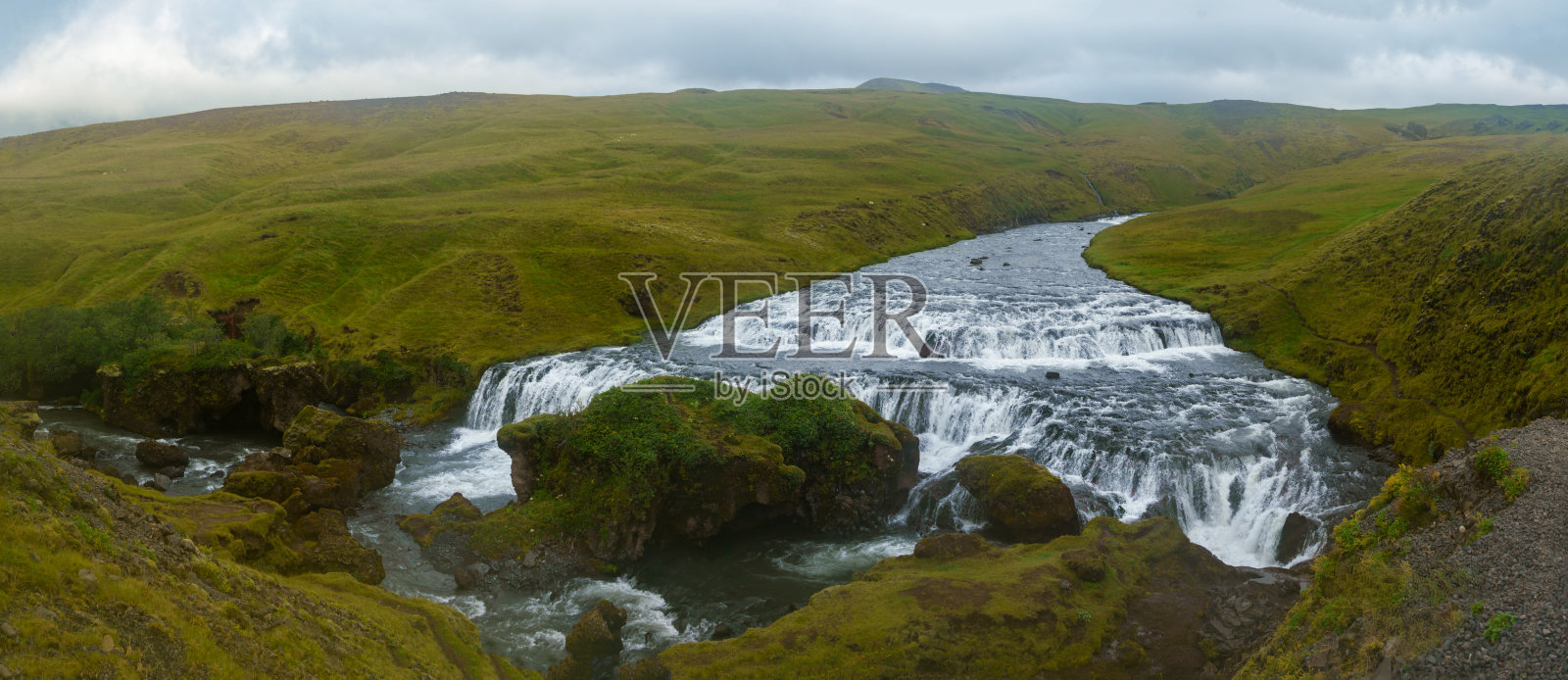 郁郁葱葱的冰岛风景中的壮观瀑布照片摄影图片