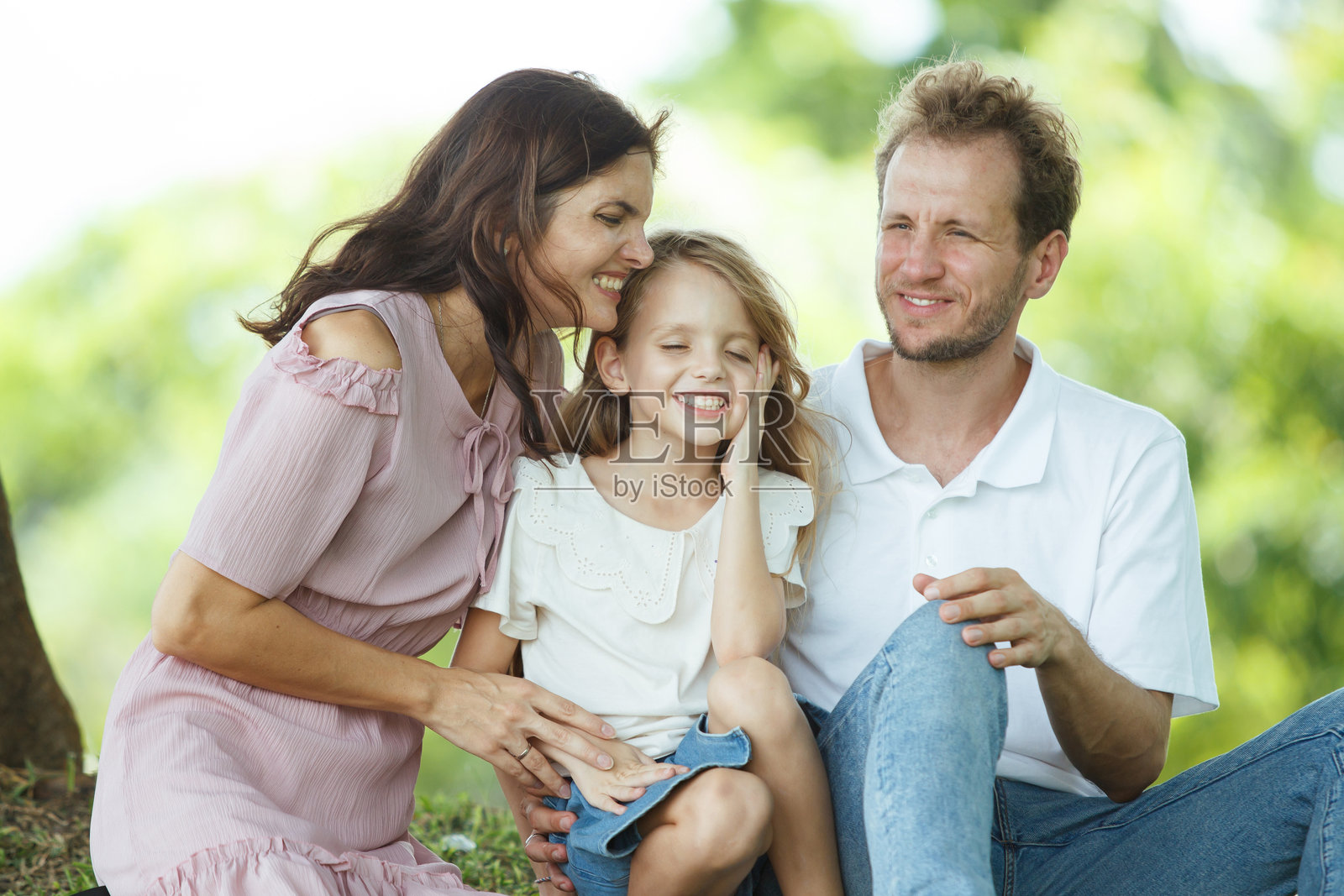 快乐的家庭在公园里放松，白人家庭由父亲、母亲和孩子们组成，一起在公园散步。照片摄影图片