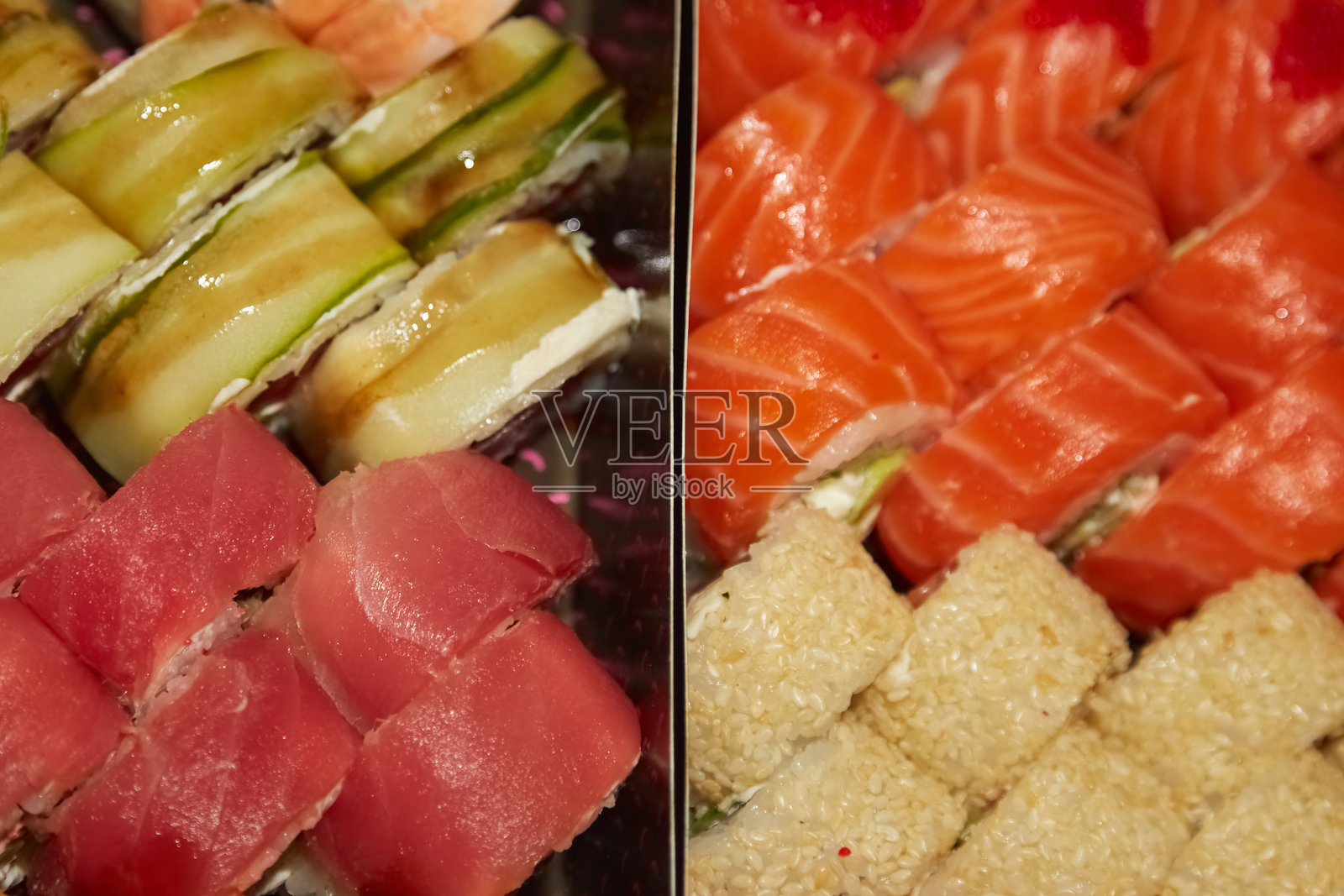 费城寿司卷整齐地摆放在黑色盒子里，温暖的光线照耀着，突显出食物的质感和吸引力。照片摄影图片