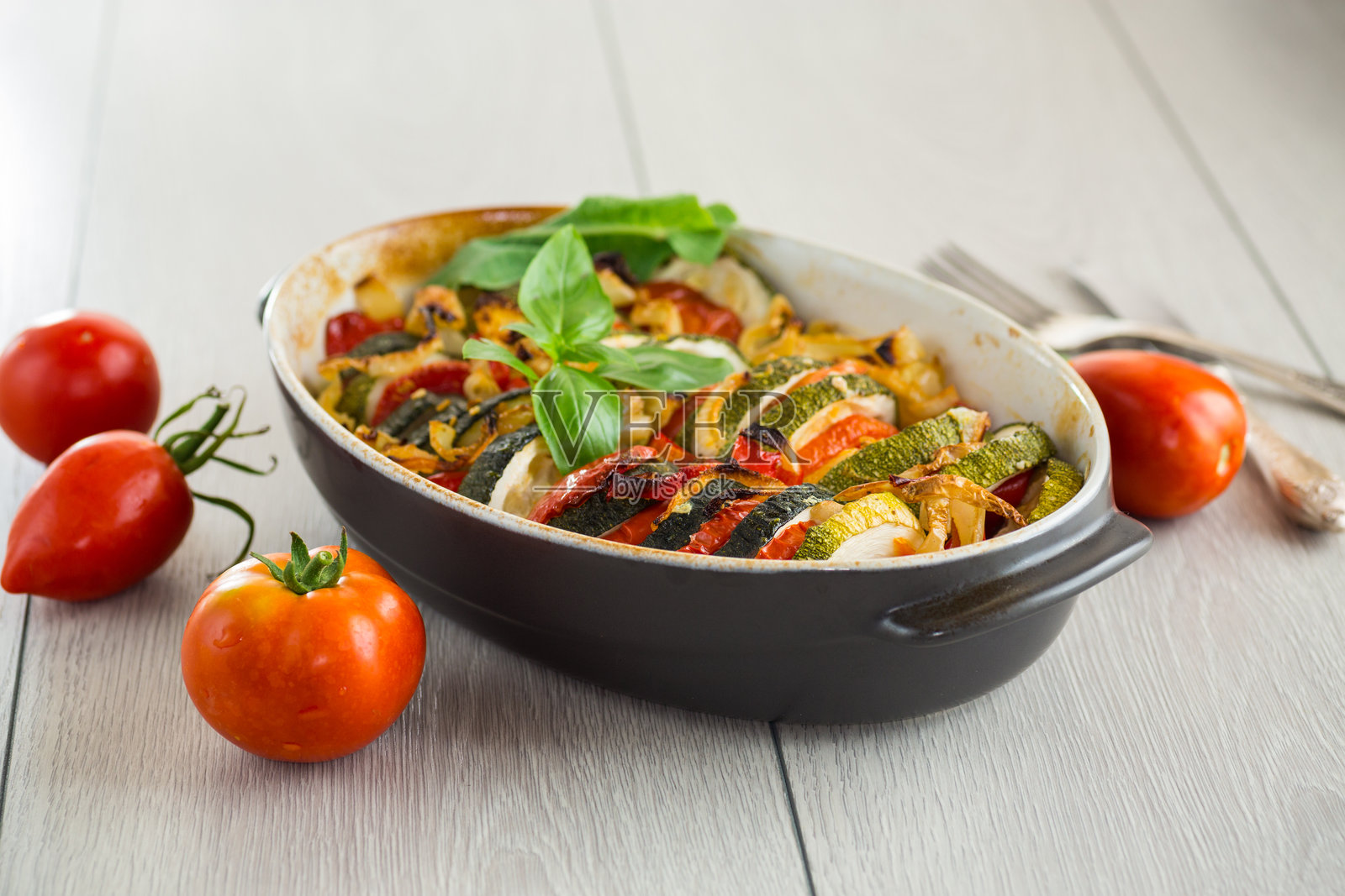 准备好的圆形烤西葫芦和番茄，放在陶瓷盘中，蔬菜小吃照片摄影图片