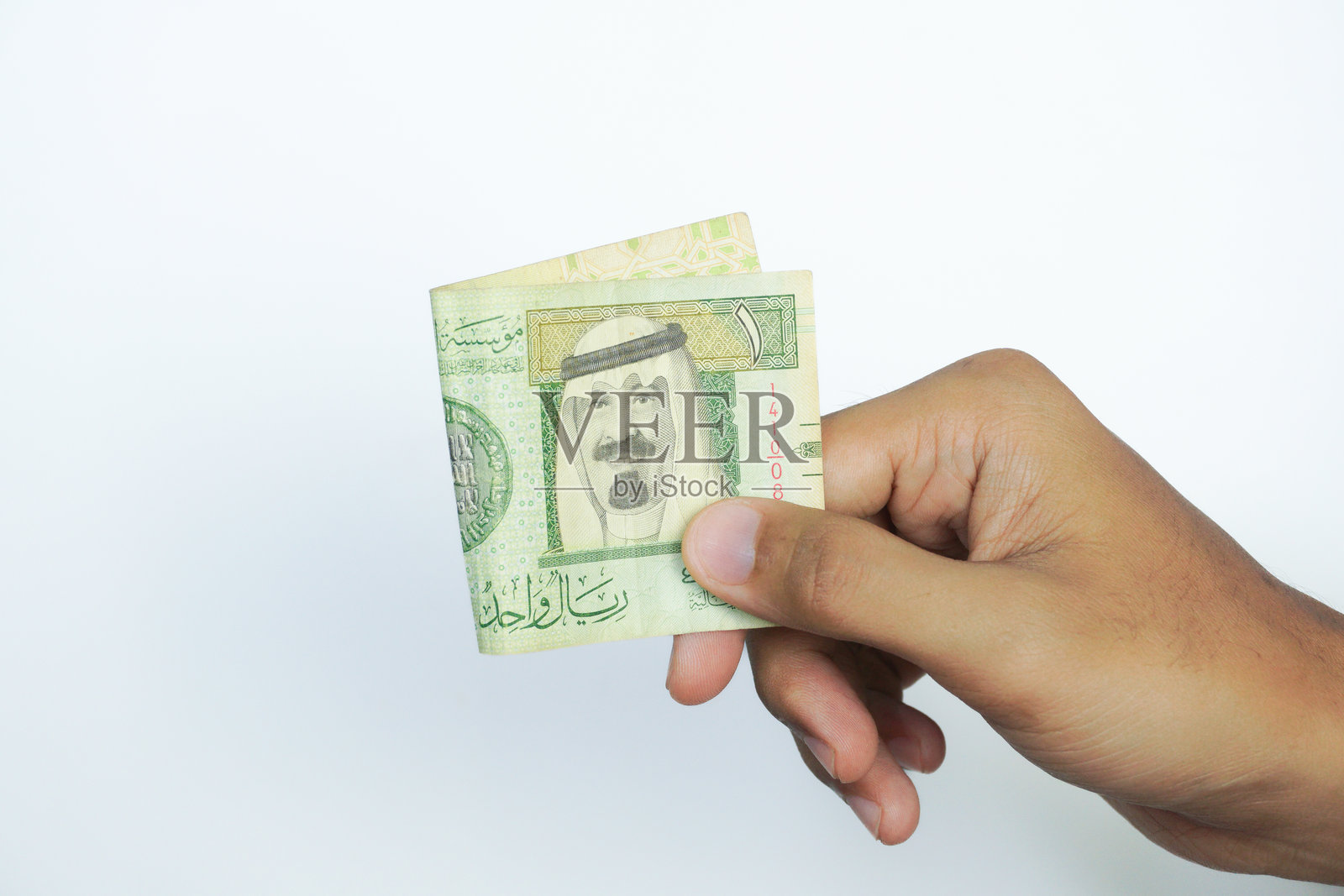 手持沙特阿拉伯里亚尔照片摄影图片