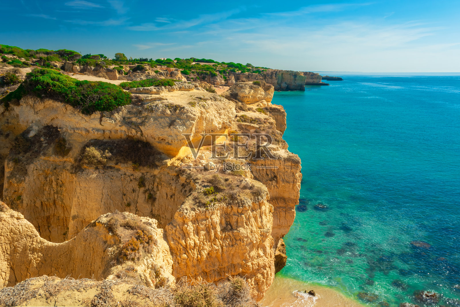 阿尔布费拉，阿尔加维地区，葡萄牙，欧洲的沙滩上黄褐色的悬崖岩石。葡萄牙大西洋沿岸夏季度假的热门旅游目的地。照片摄影图片