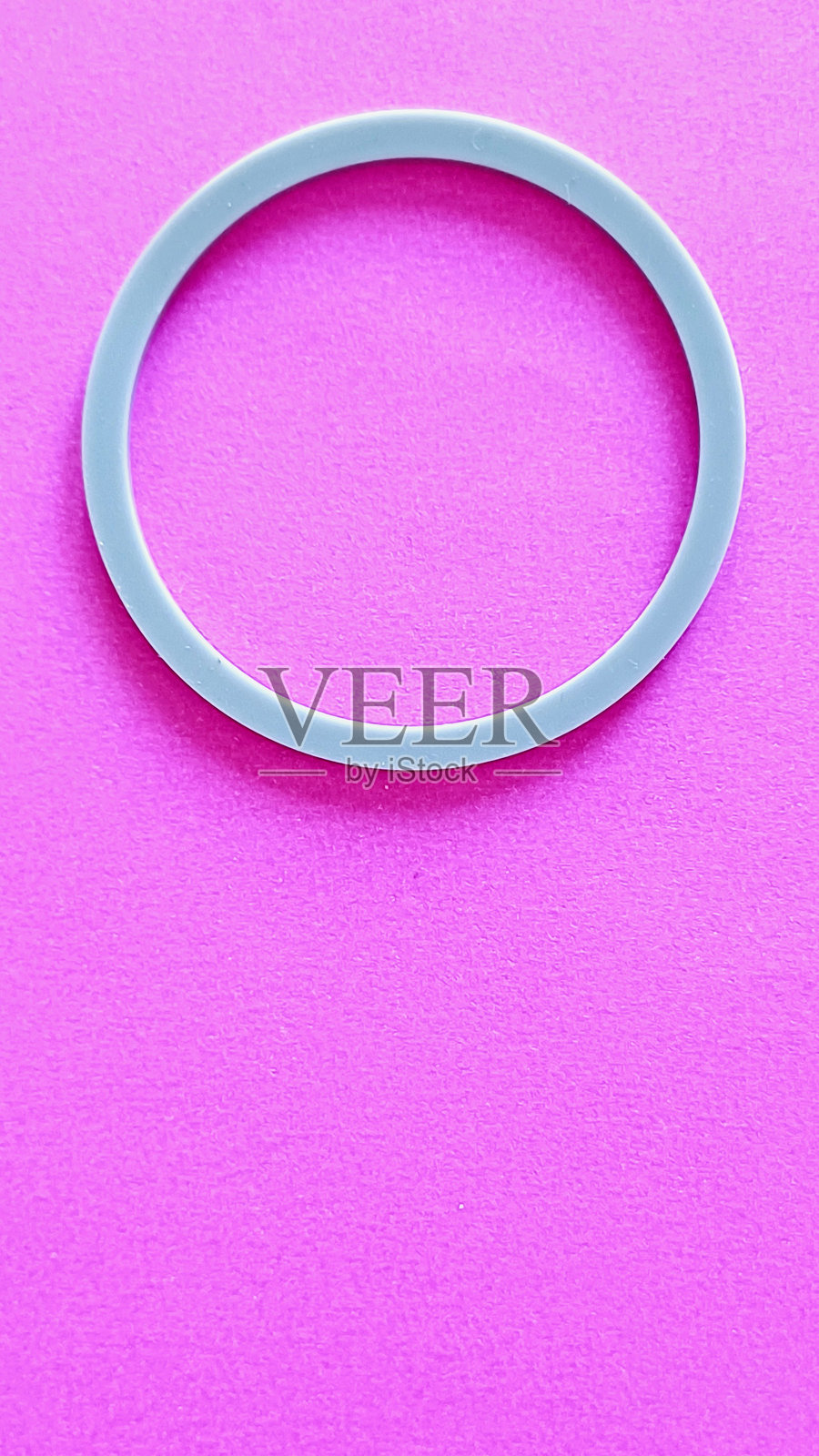 粉色背景上的灰色塑料环。照片摄影图片