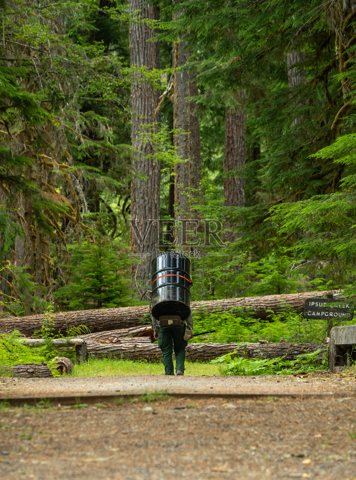 公园护林员携带空的五十加仑桶进入偏远地区进行厕所维护照片摄影图片