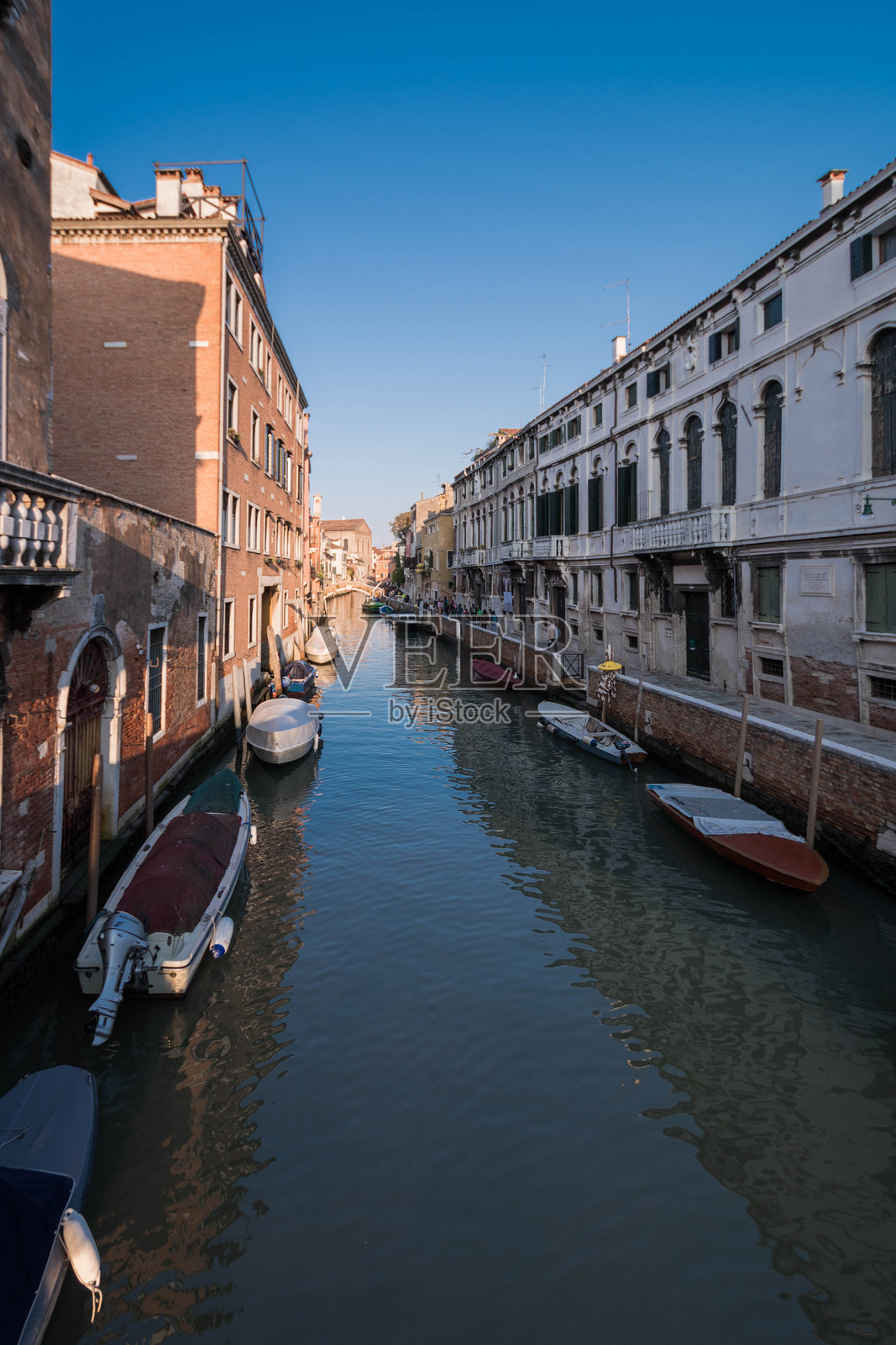 狭窄的运河映照着意大利威尼斯的建筑照片摄影图片