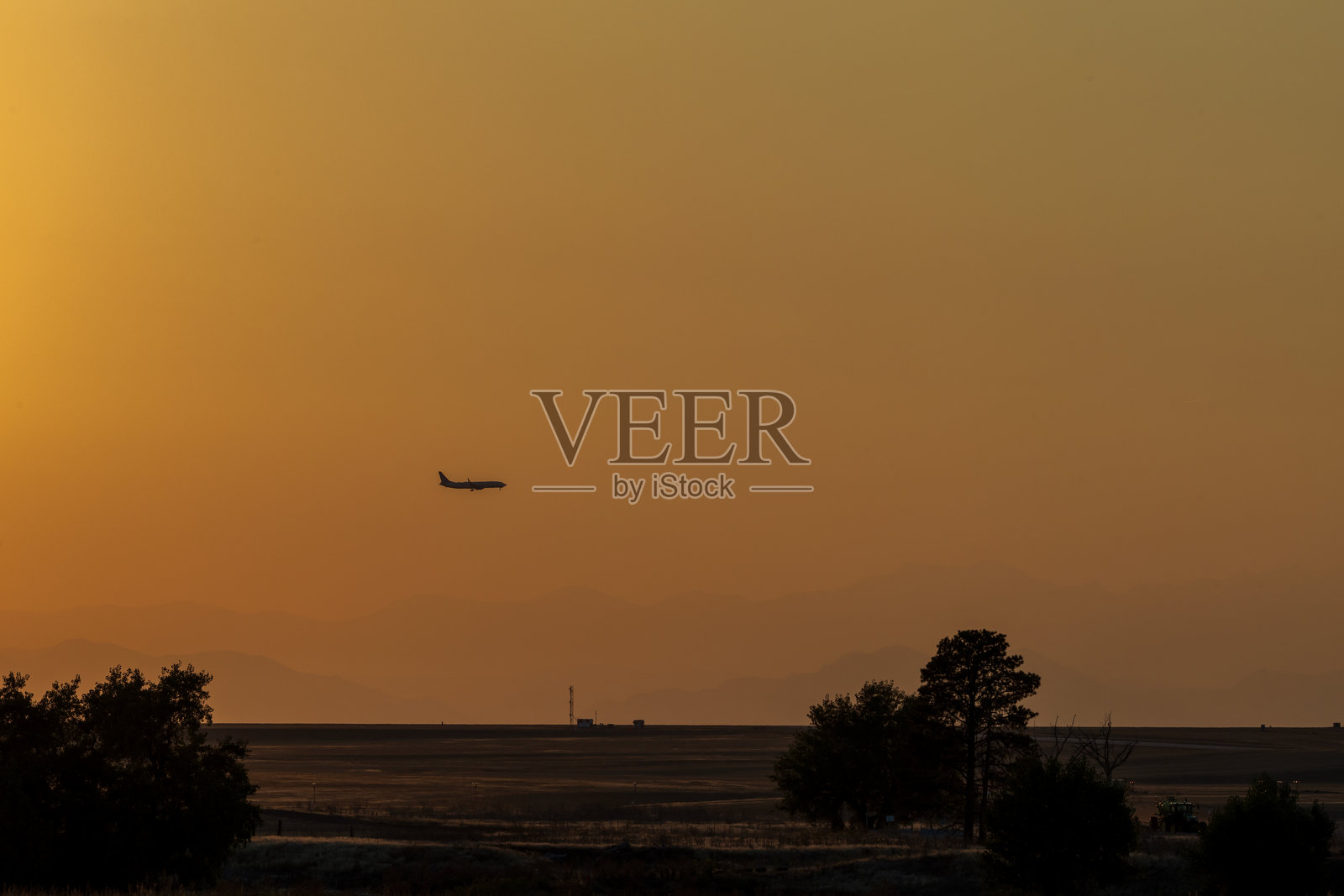 一架飞机在科罗拉多草原上空的夕阳天空中飞行照片摄影图片