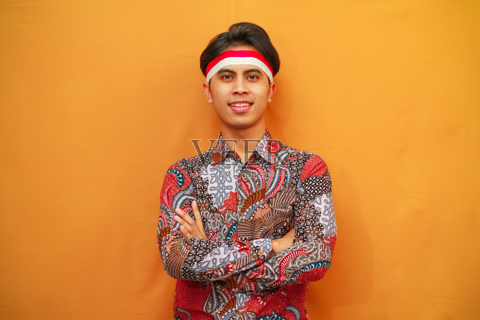 身穿巴蒂克衬衫的帅气印尼男子，自信地庆祝8月17日印尼独立日，朝镜头摆姿势。照片摄影图片