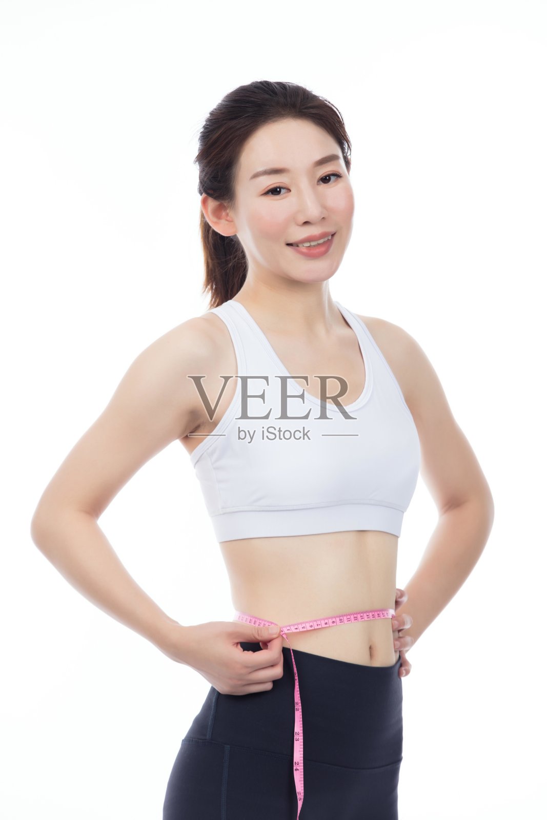 亚洲女性用卷尺测量自己的腰围照片摄影图片