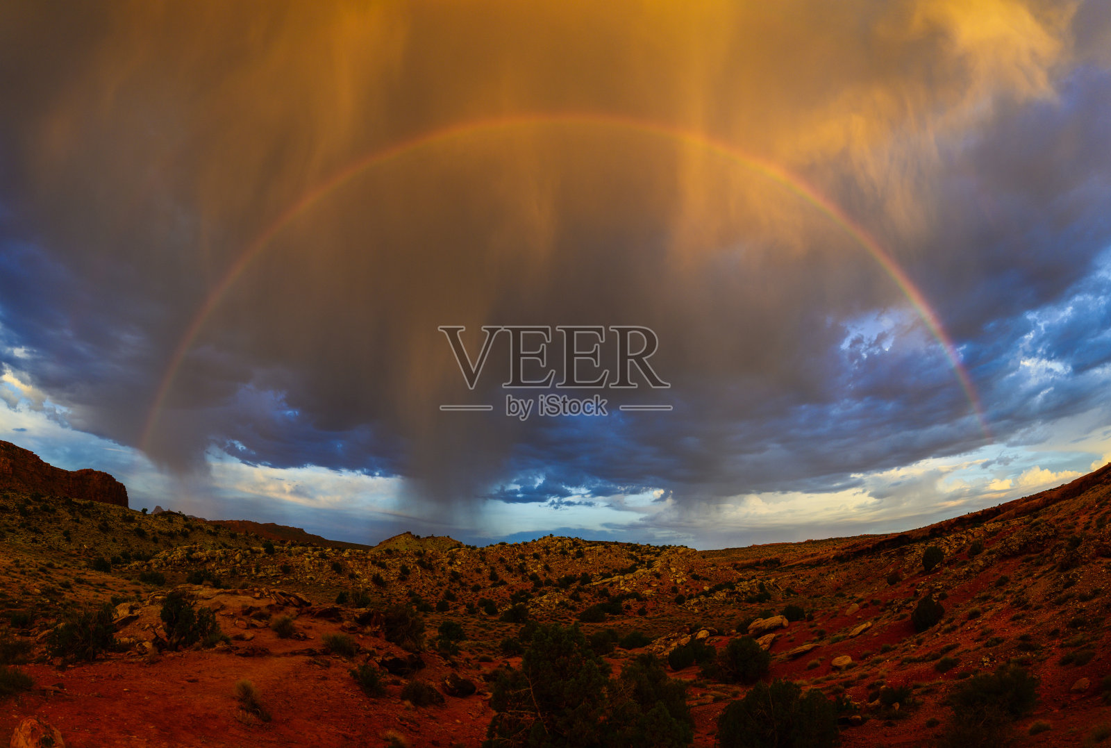 犹他州拱门国家公园日出时的完整彩虹与暴风云照片摄影图片