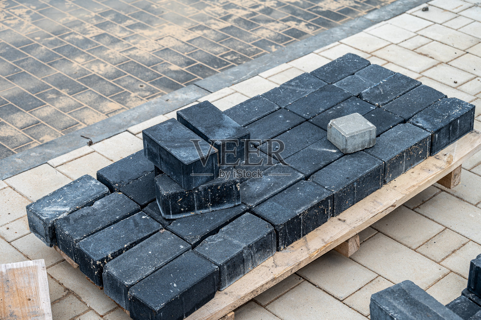 用于铺设人行道的铺路石堆放在建筑托盘上。照片摄影图片