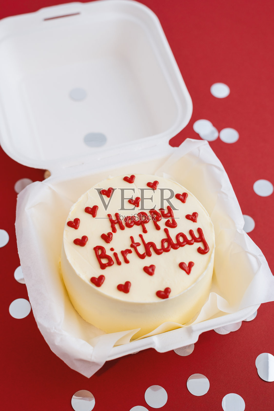 红色背景上的便当蛋糕，上面写着“生日快乐”。照片摄影图片