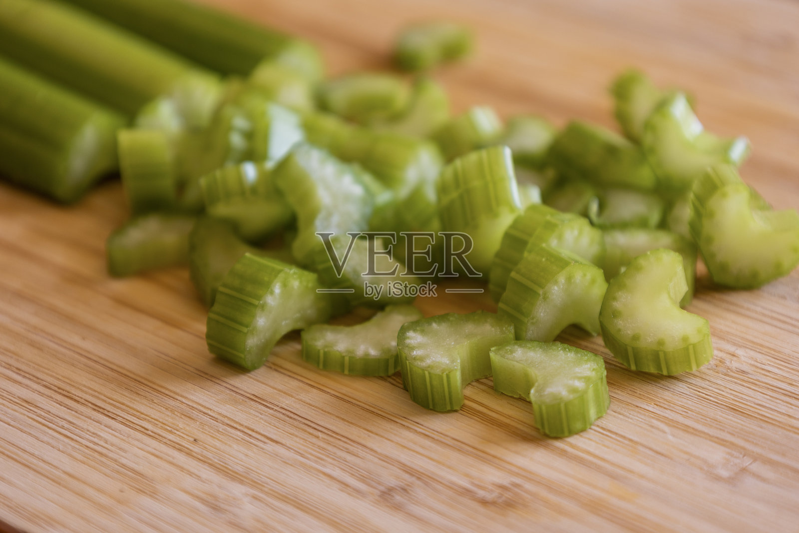 新鲜有机切碎的芹菜棒在木砧板上的特写照片摄影图片