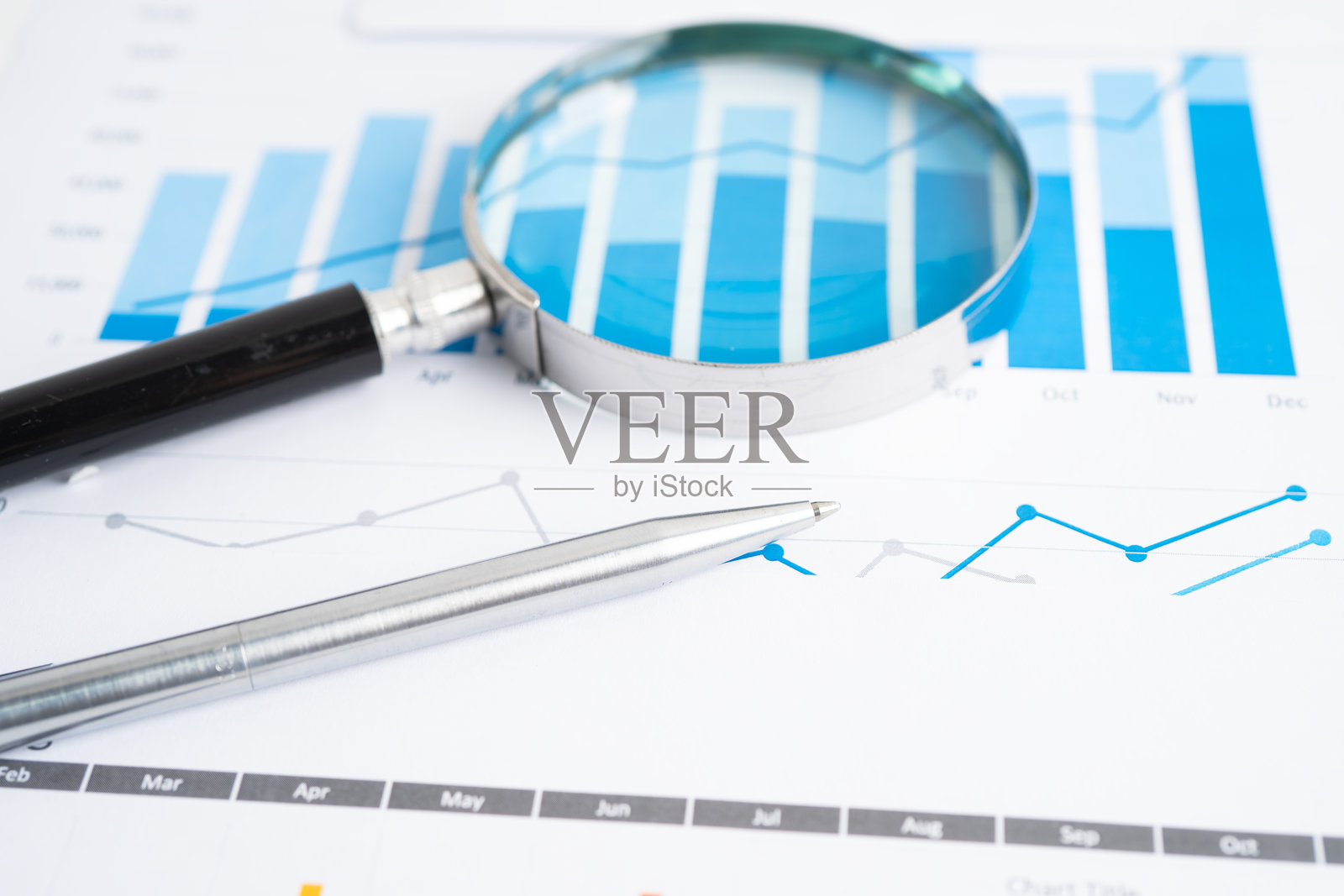 放大镜放在图表上。金融业务与交易。照片摄影图片