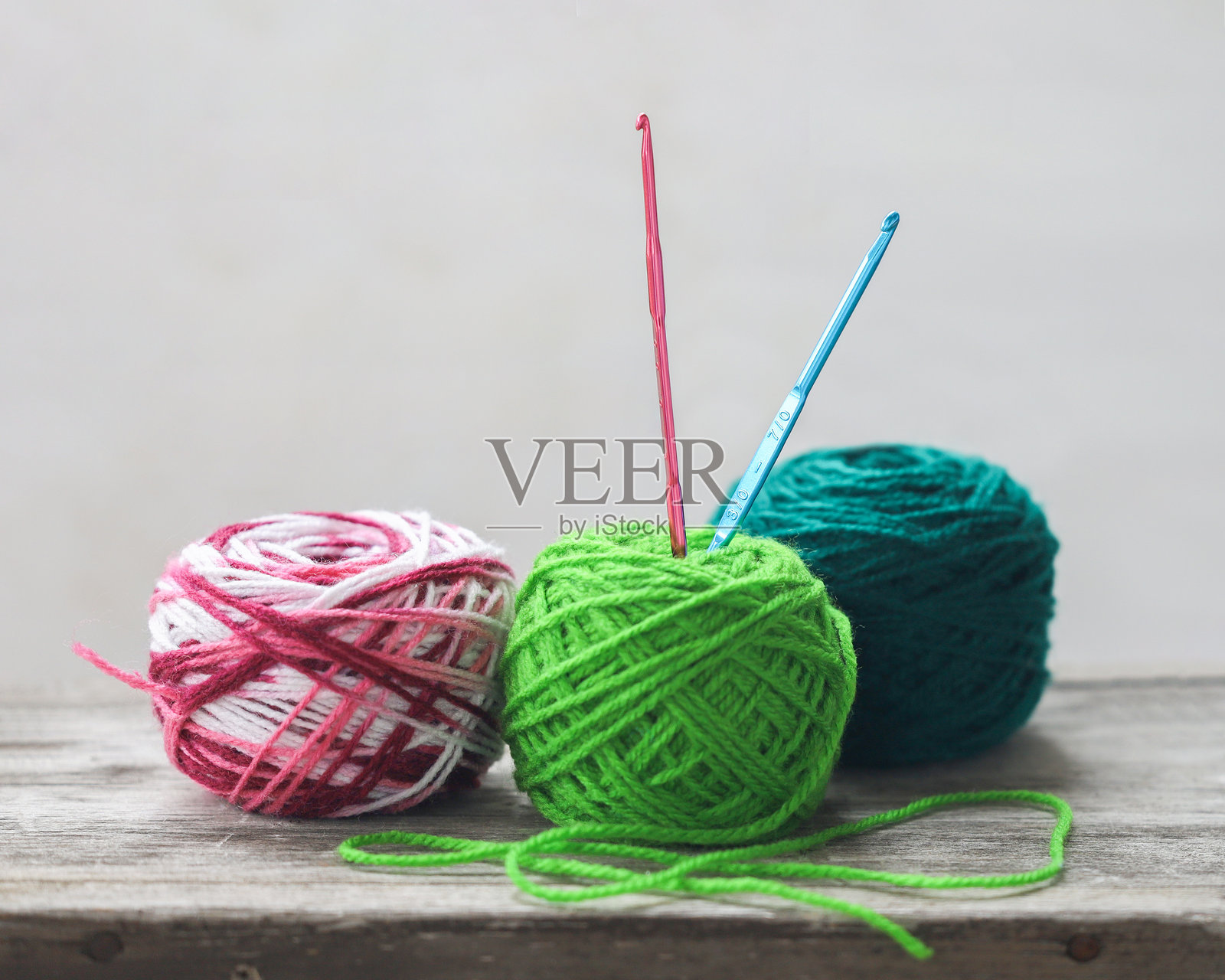 编织毛线。绿色毛线球和钩针。照片摄影图片