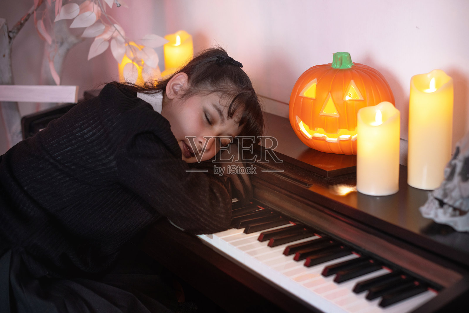 穿着黑色裙子的年轻女孩在钢琴上睡觉照片摄影图片