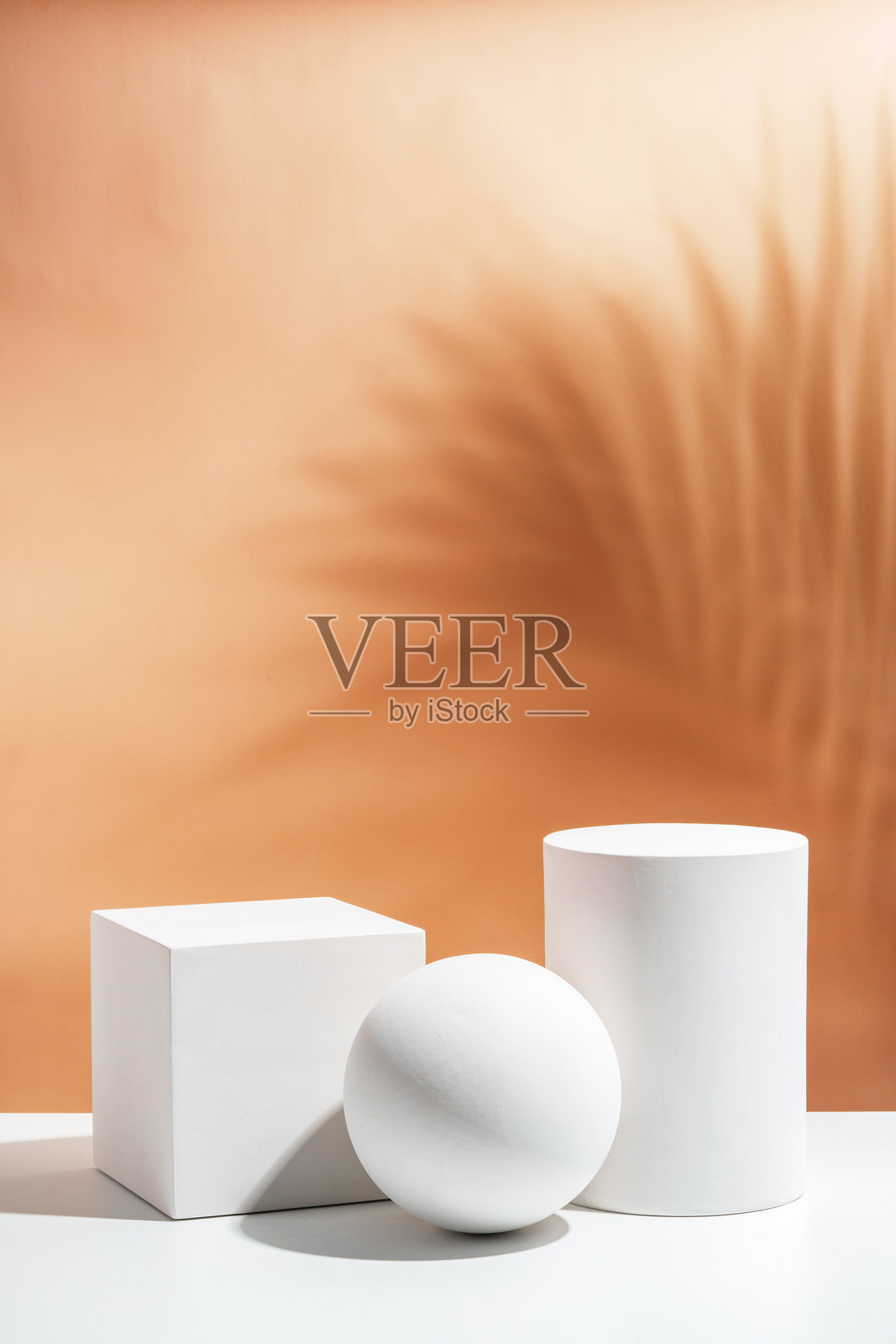 白色几何形状在柔和的桃色背景上时尚地排列，营造出极简风格的环境照片摄影图片