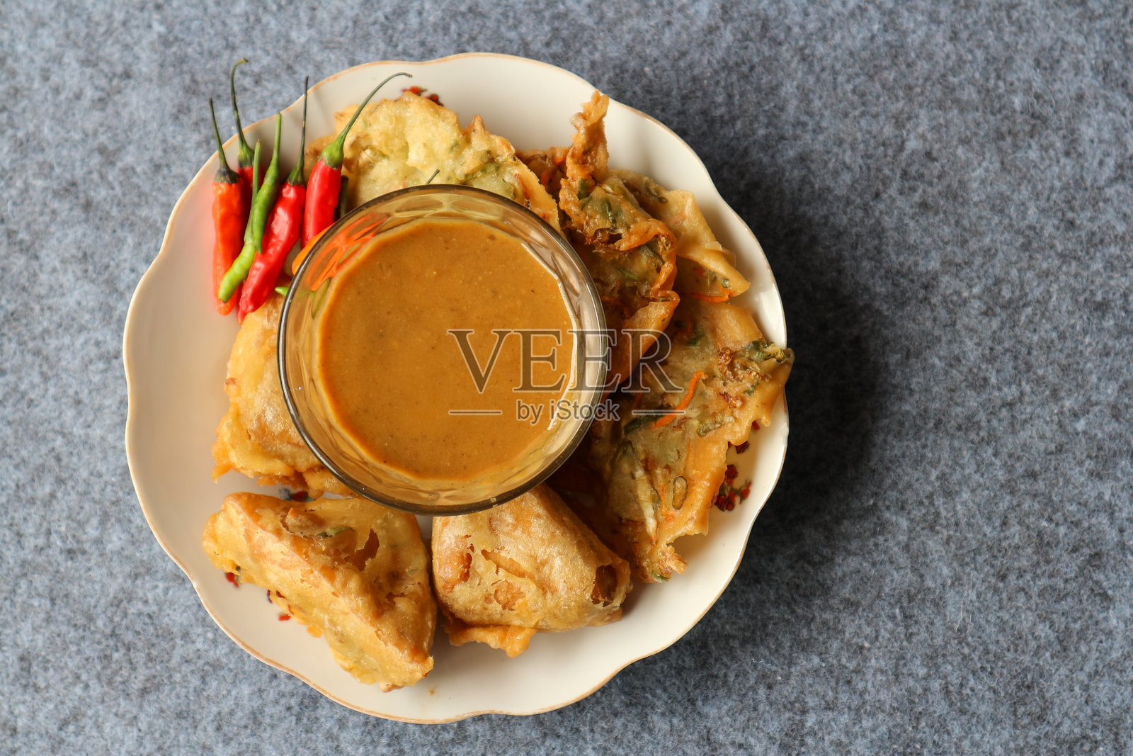 典型的印尼炸食品，蔬菜饼和蔬菜豆腐，配以辛辣花生酱，背景为灰色，适用于食谱、文章和目录。照片摄影图片