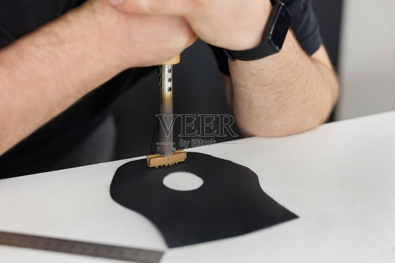 师傅在紧固和修复过程中对方向盘进行雕刻和铭刻。照片摄影图片