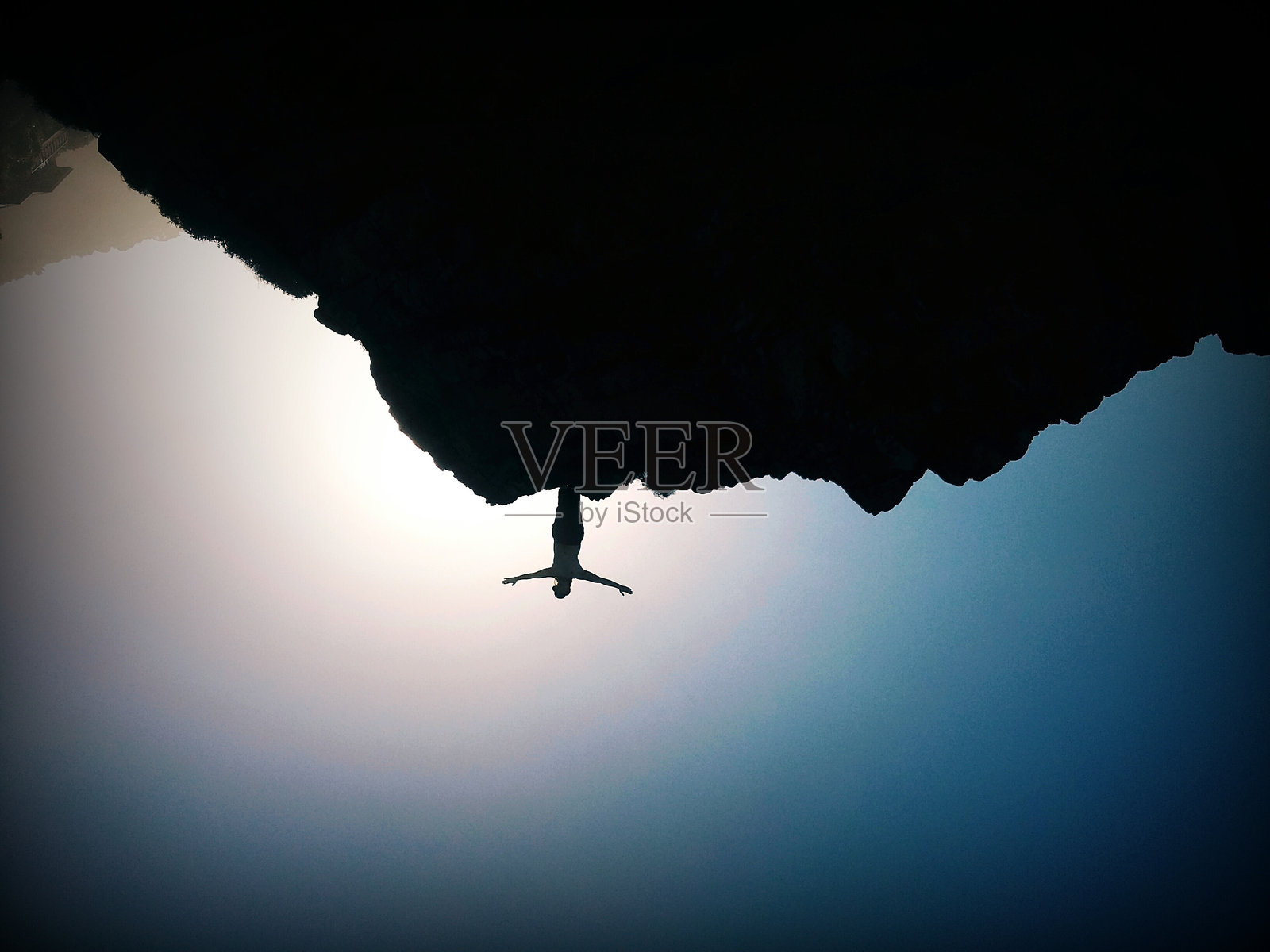 低角度视图的剪影女性，举起手臂站在山上照片摄影图片