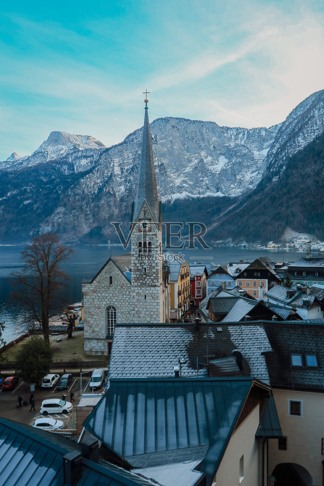 奥地利哈尔施塔特宁静的冬晨，展示了迷人的教堂和白雪皑皑的山脉照片摄影图片