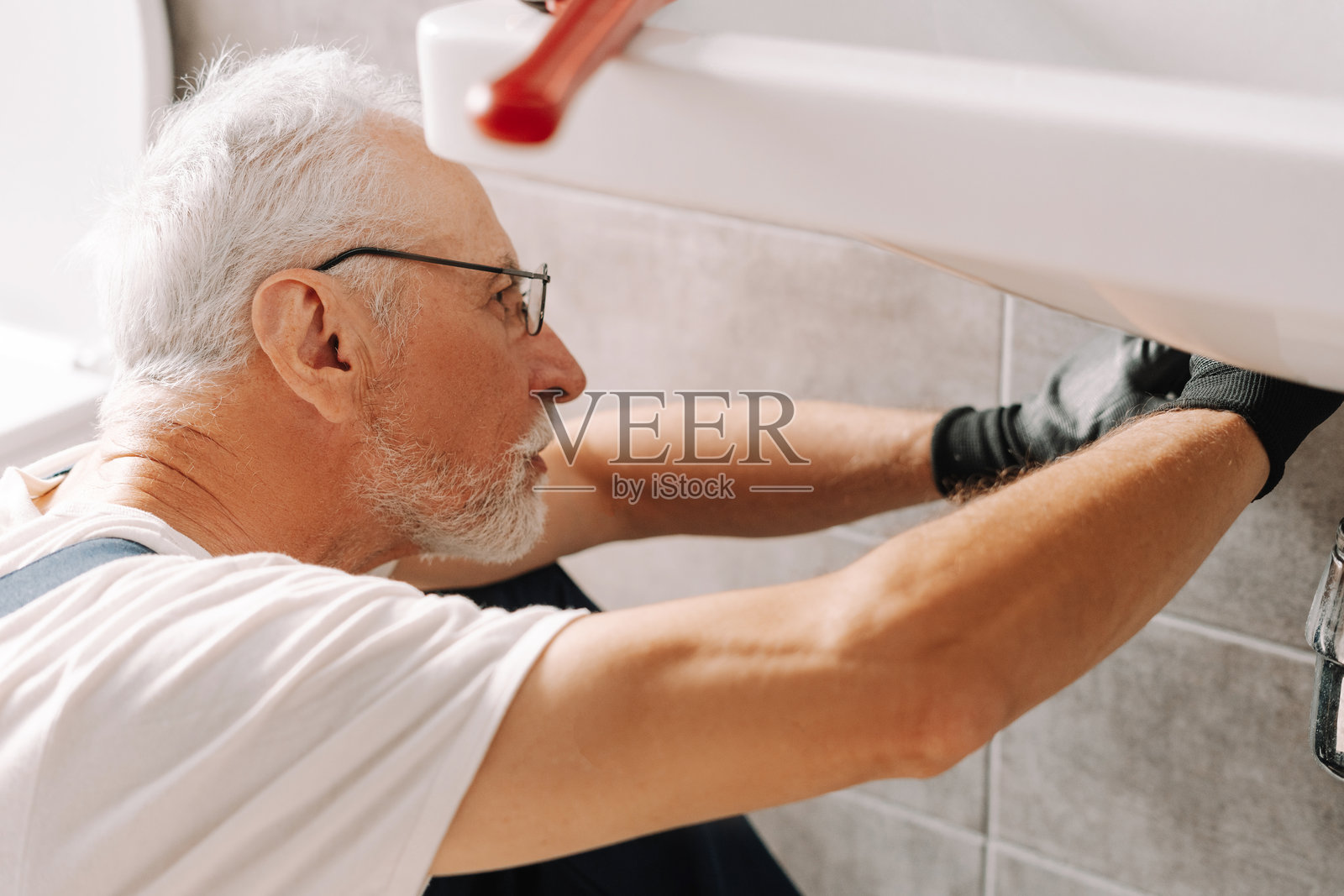 资深水管工在浴室安装水槽照片摄影图片