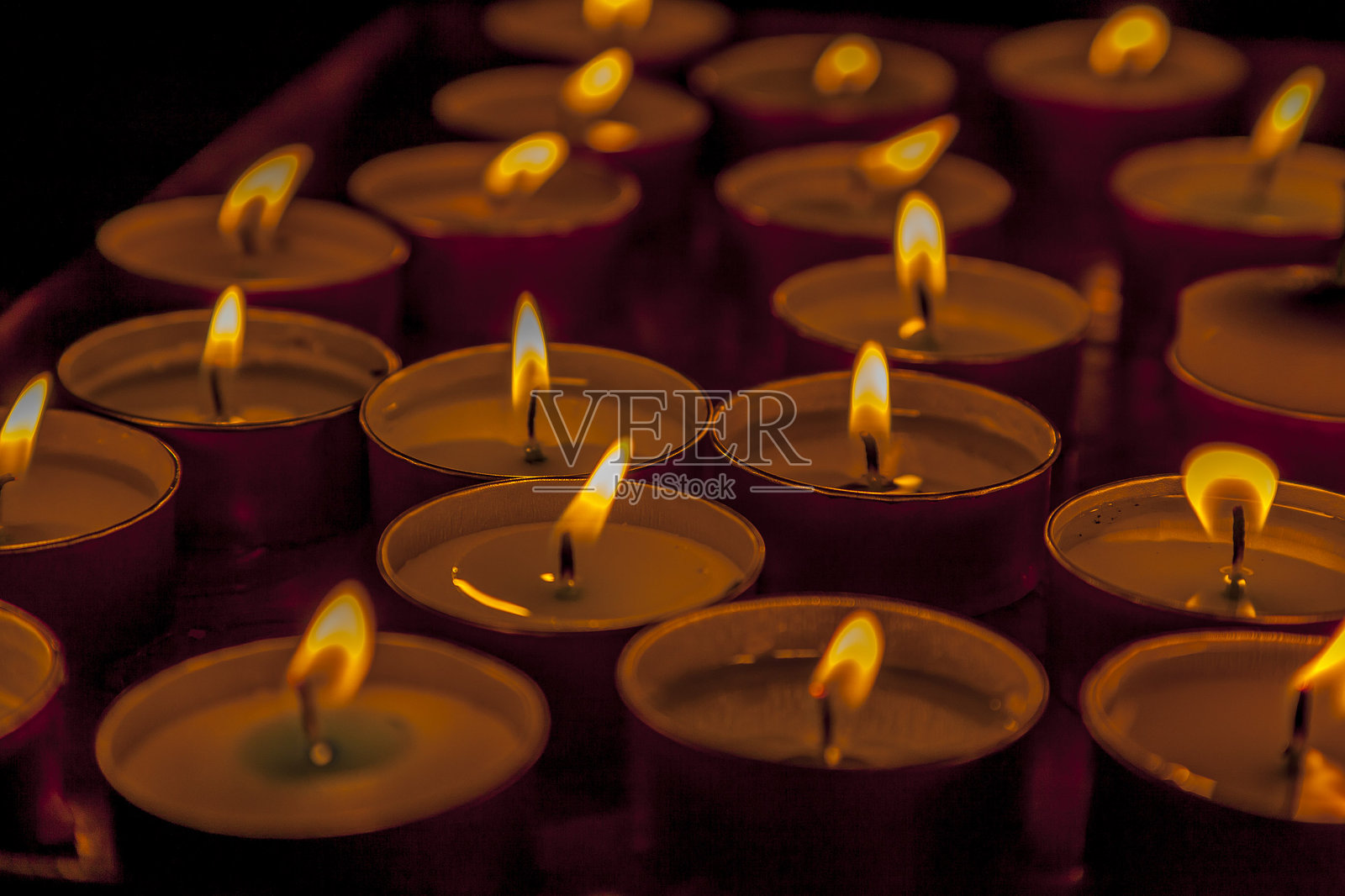 黑暗房间中燃烧的茶蜡烛特写照片摄影图片