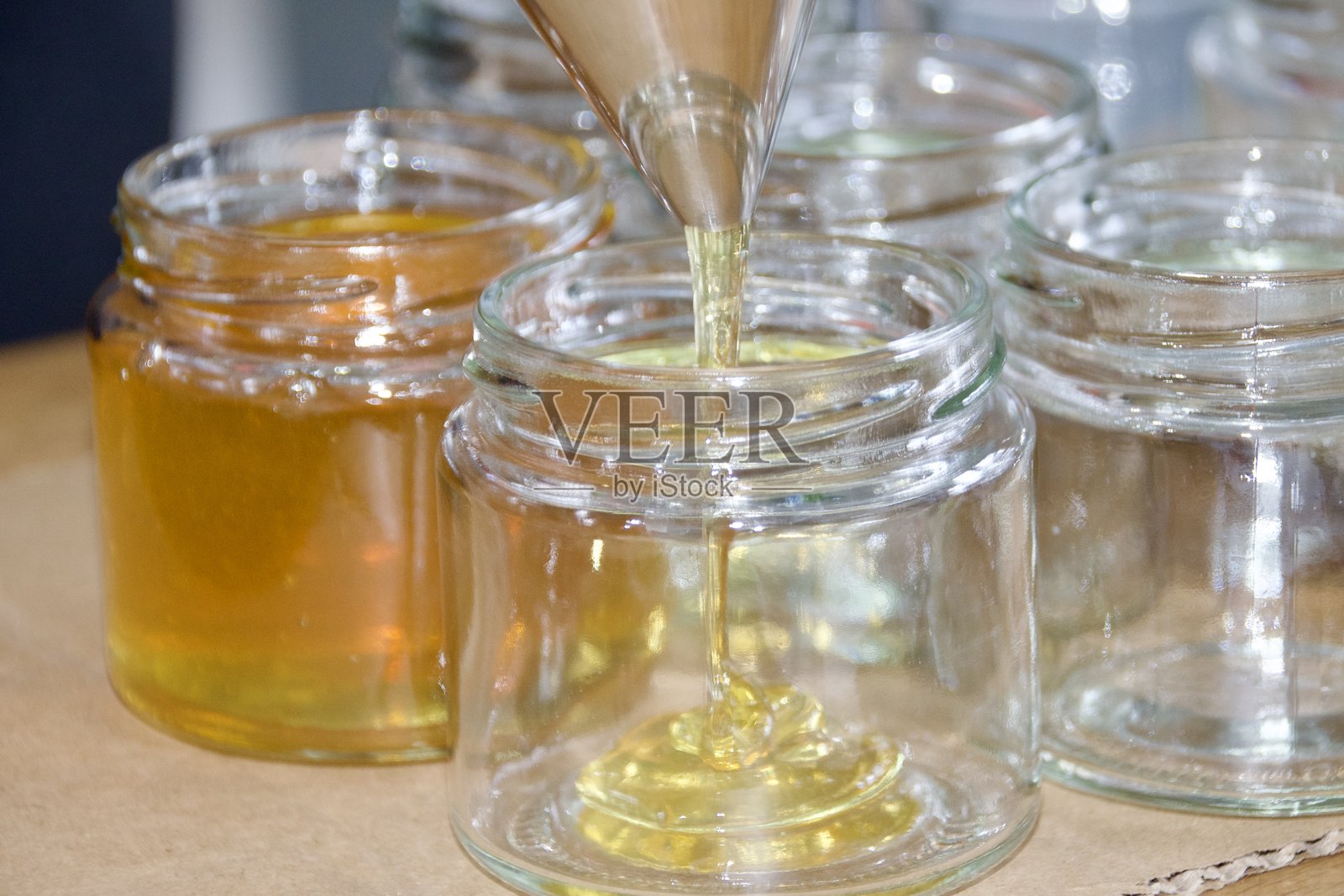 蜂蜜倒入罐子中照片摄影图片