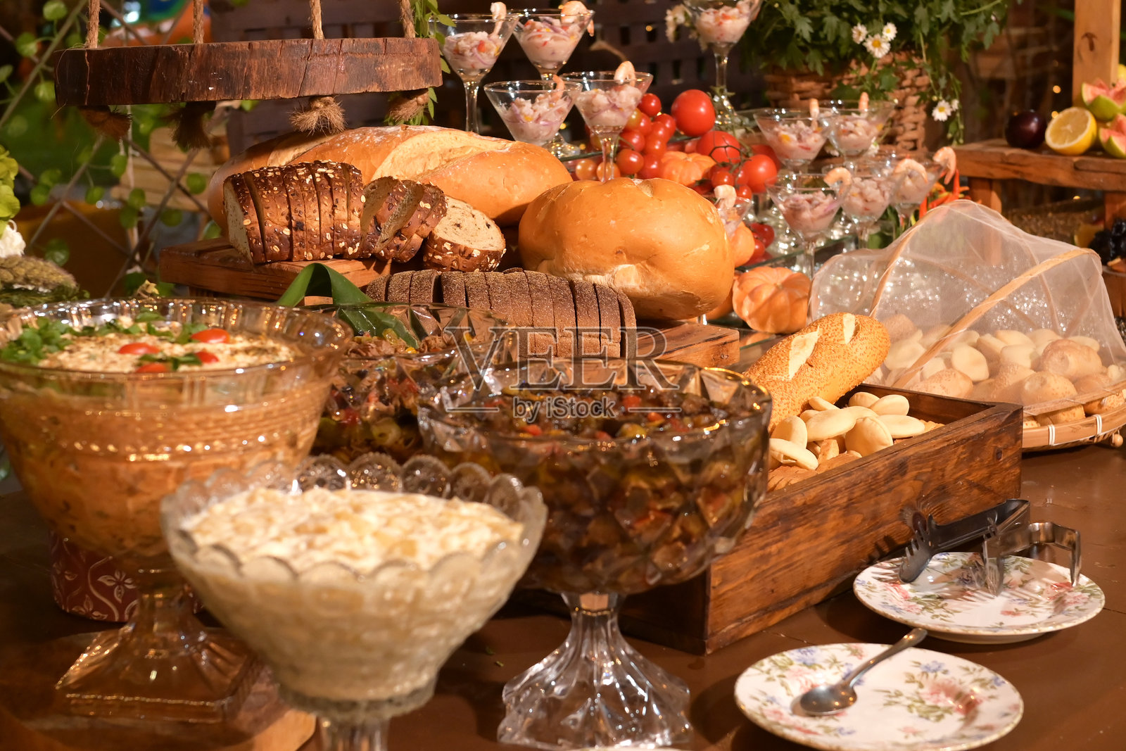 早餐桌上摆放着水果、面包、奶酪、小吃、热带沙拉、火腿、葡萄和栗子，健康食品。照片摄影图片