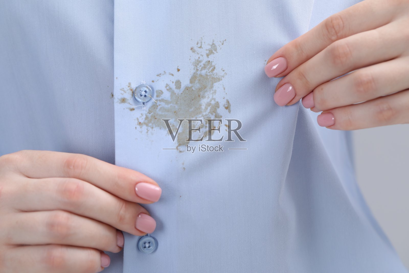女人展示她衬衫上的污渍，特写镜头照片摄影图片
