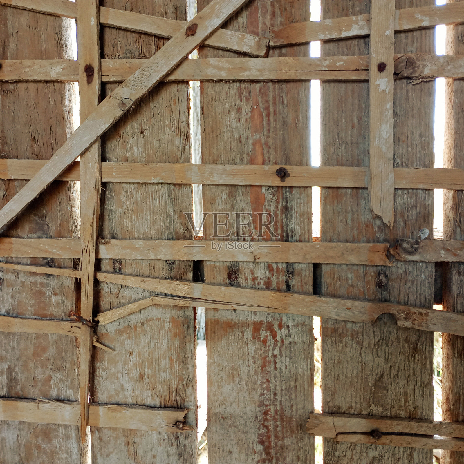 旧木墙的方形背景，上面贴满了木板。与建筑主题和工业背景相关。照片摄影图片