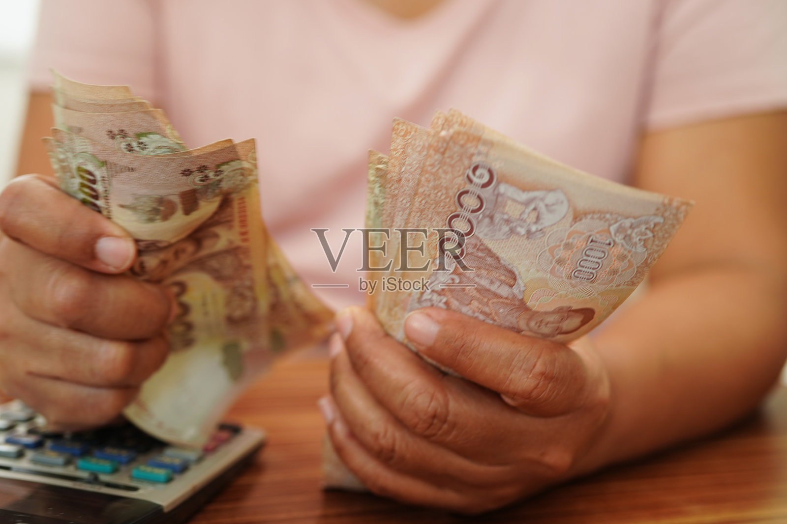 亚洲女性在手中数着泰铢纸币，投资经济、会计业务和银行。照片摄影图片