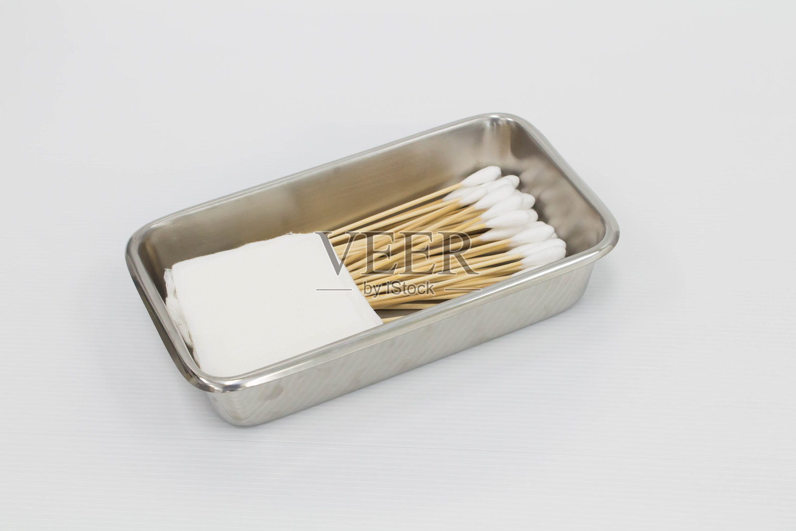 白色背景上金属容器中的棉签俯视图照片摄影图片